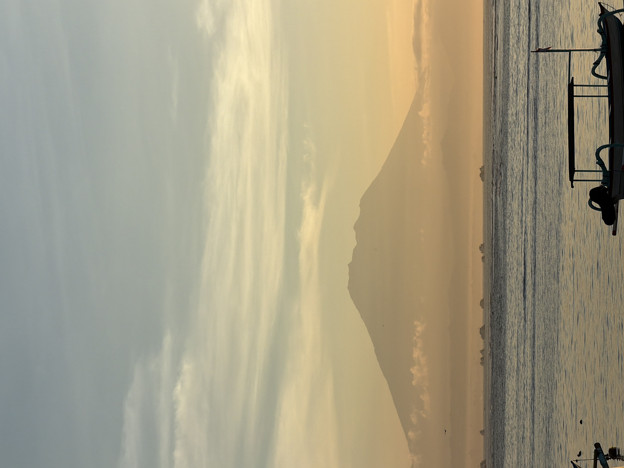 Sunset over Denpasar beach with outrigger boats offshore
