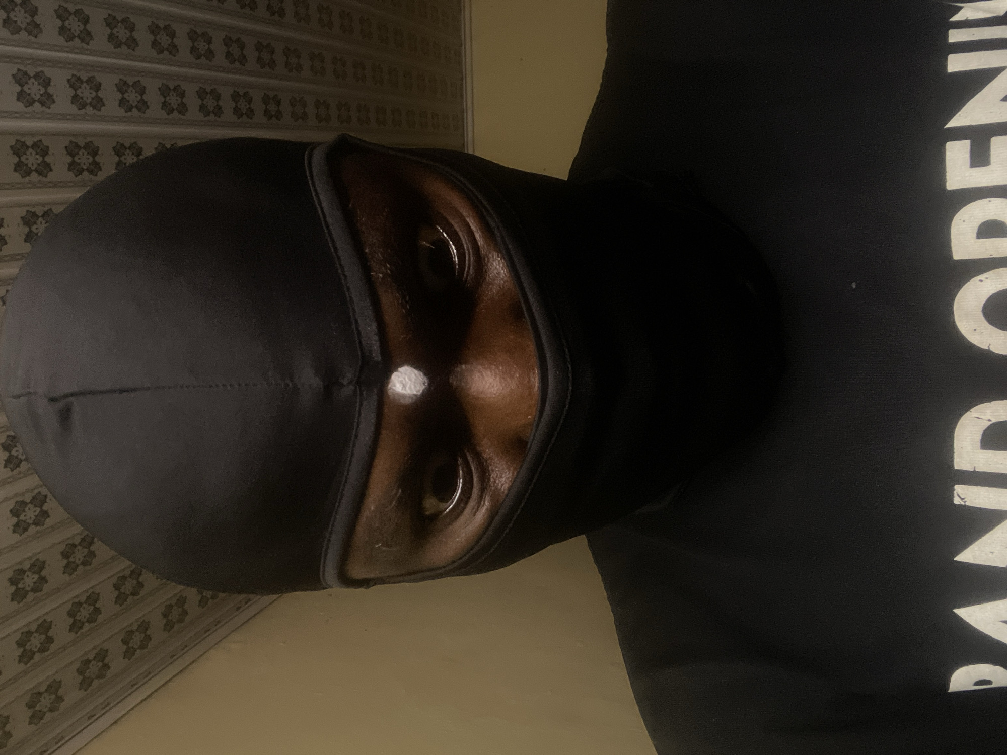 Masked individual photographed multiple times indoors in Jos, Nigeria