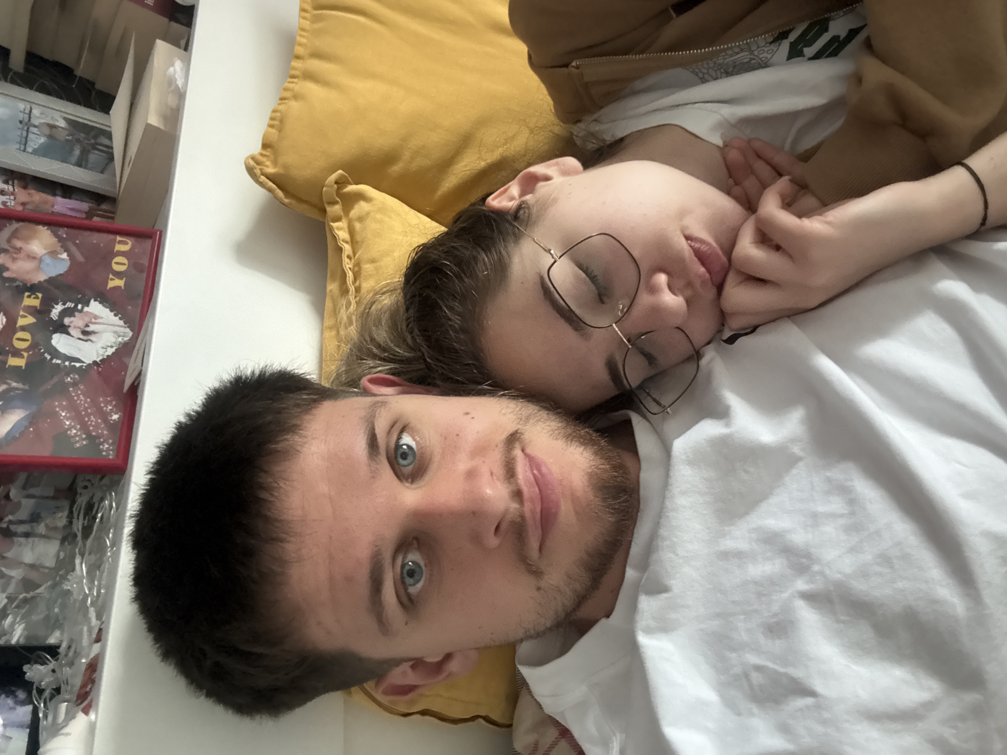 Couple relaxes in bed while watching videos in Bulgaria