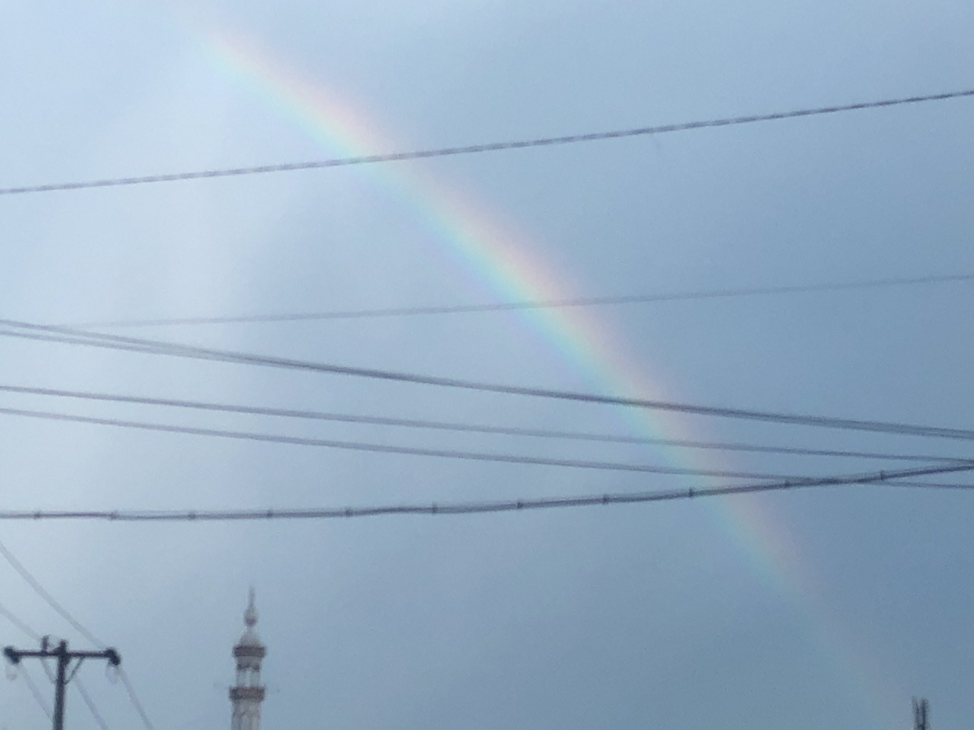 Rainbow appears over Medan streets during overcast morning