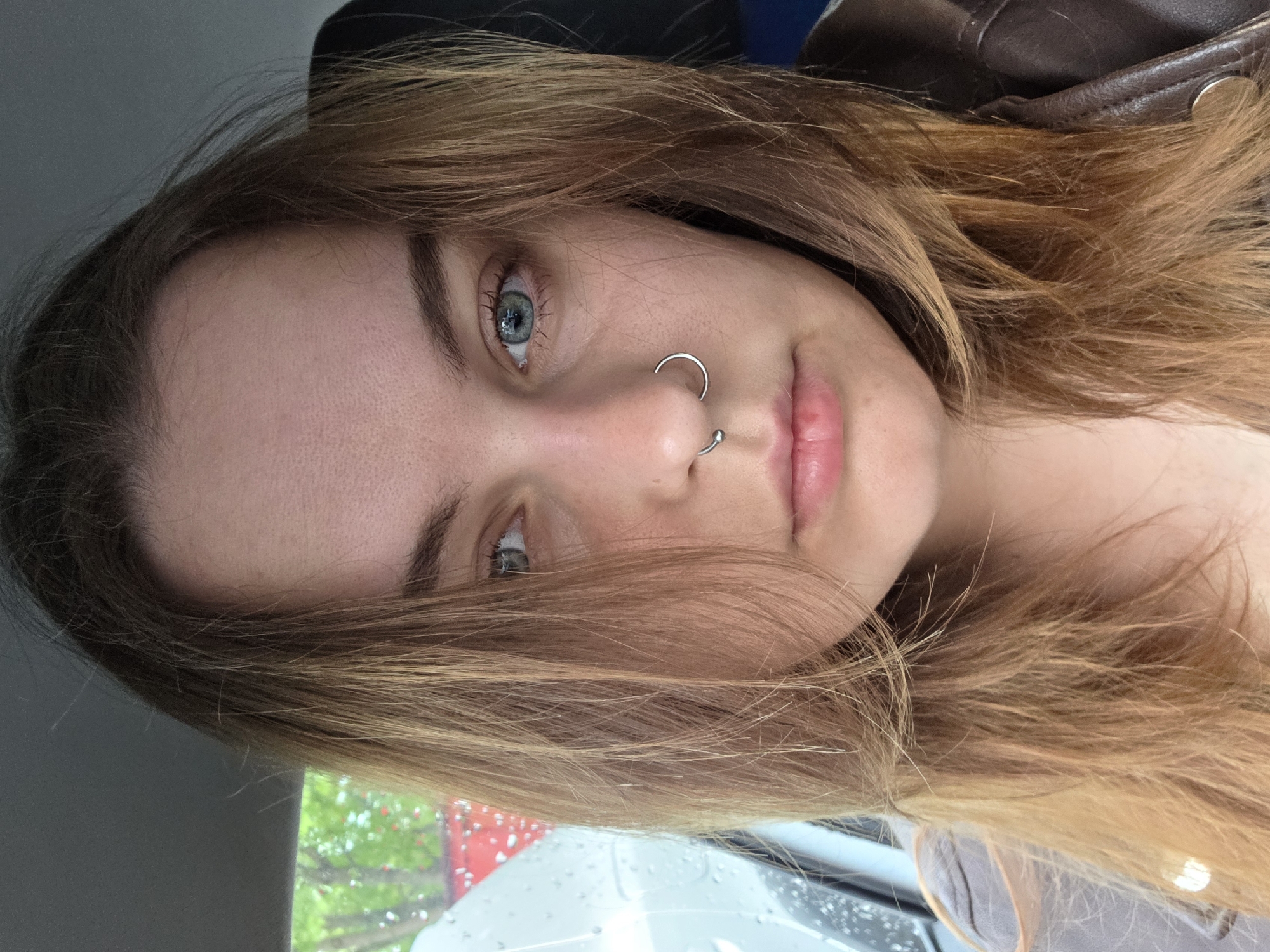 Woman photographed in car interior during rainy morning