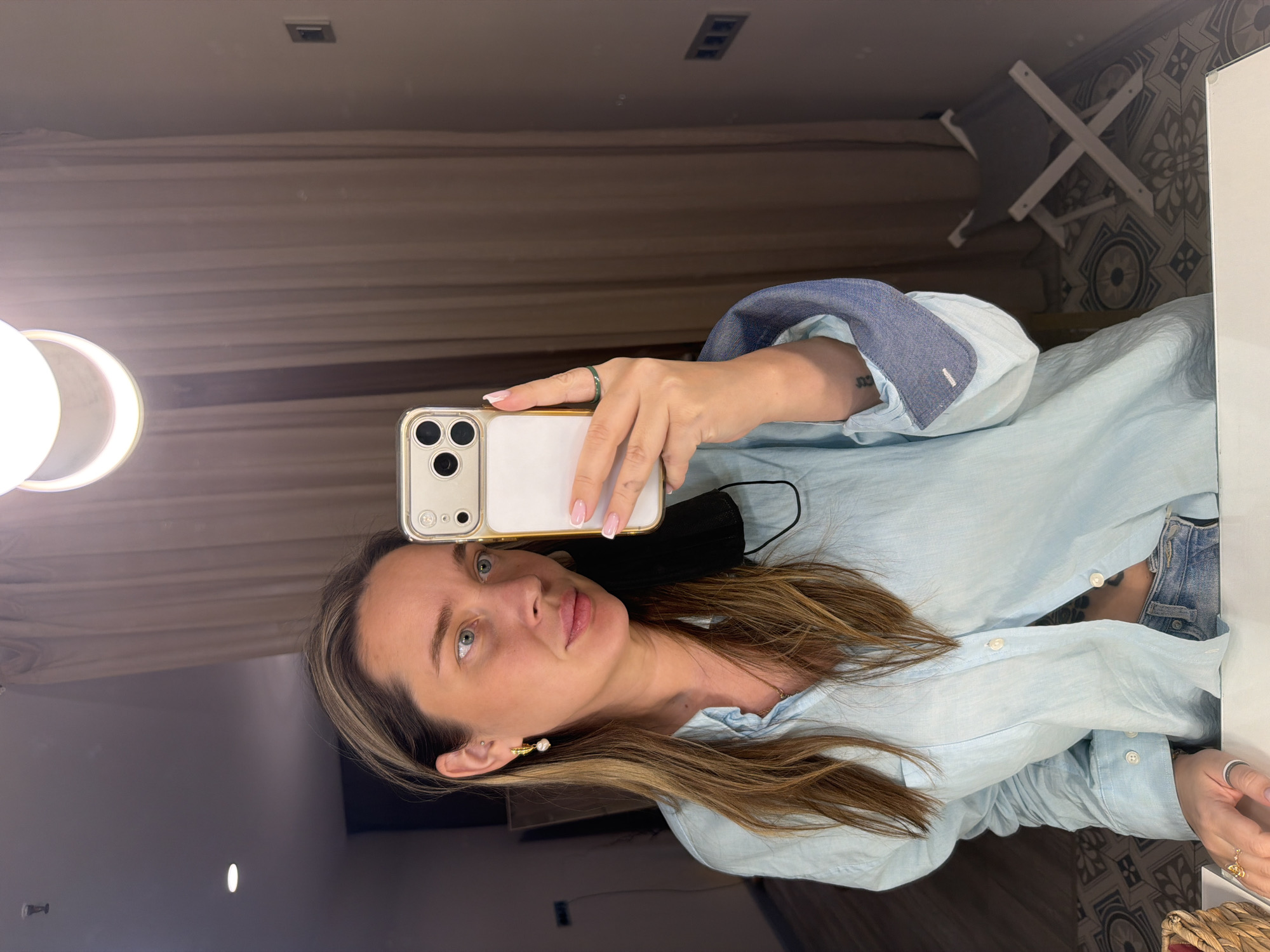Woman takes mirror selfie with gold iPhone in Moscow