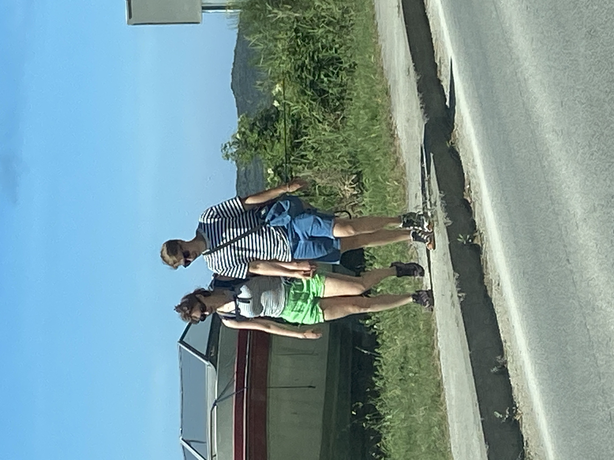 Pedestrians walk roadside in Prijevor, Montenegro morning scene