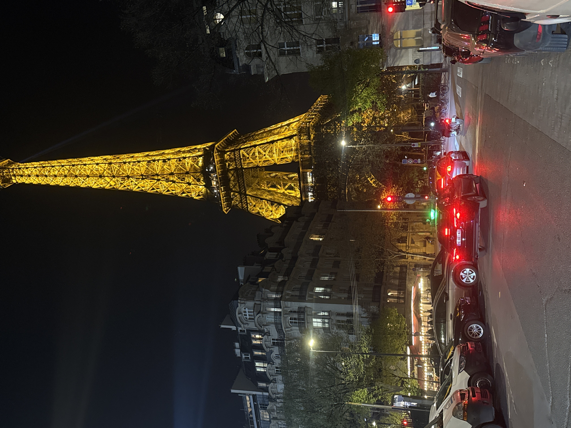 Eiffel Tower illuminated with searchlights during evening hours in Paris