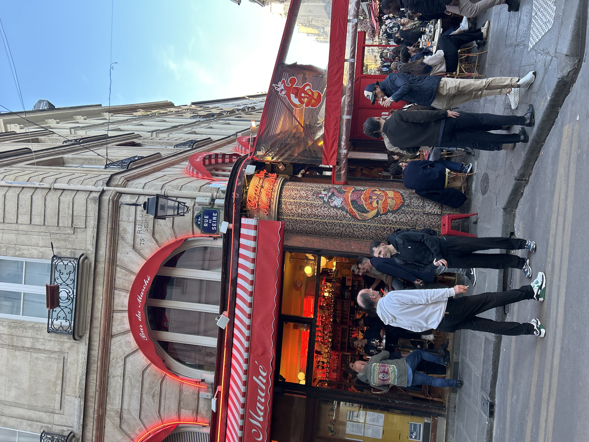Daytime street activity captured on Rue de Seine, Paris
