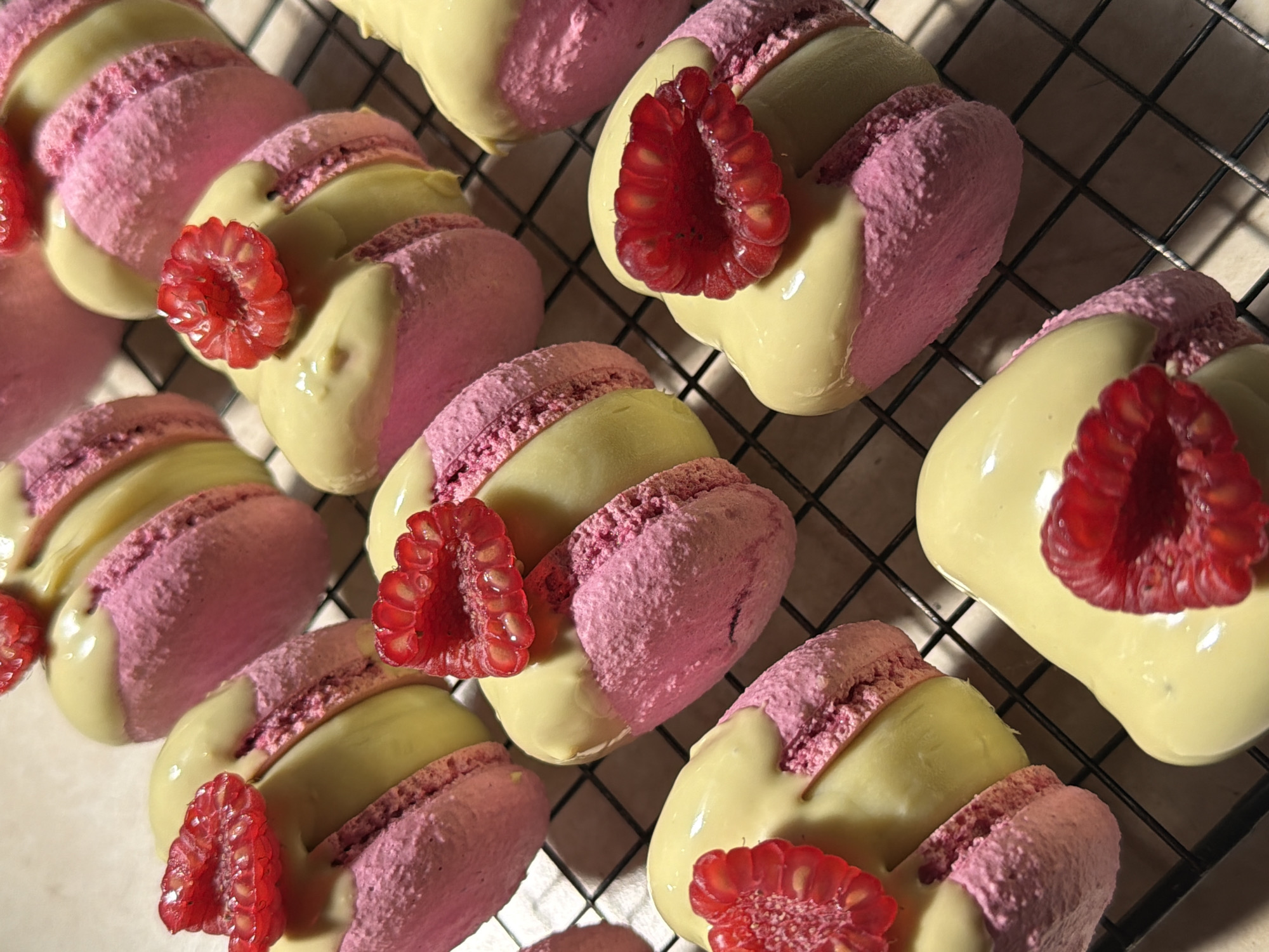Fresh macarons and eclairs cooling on racks in Tel Aviv