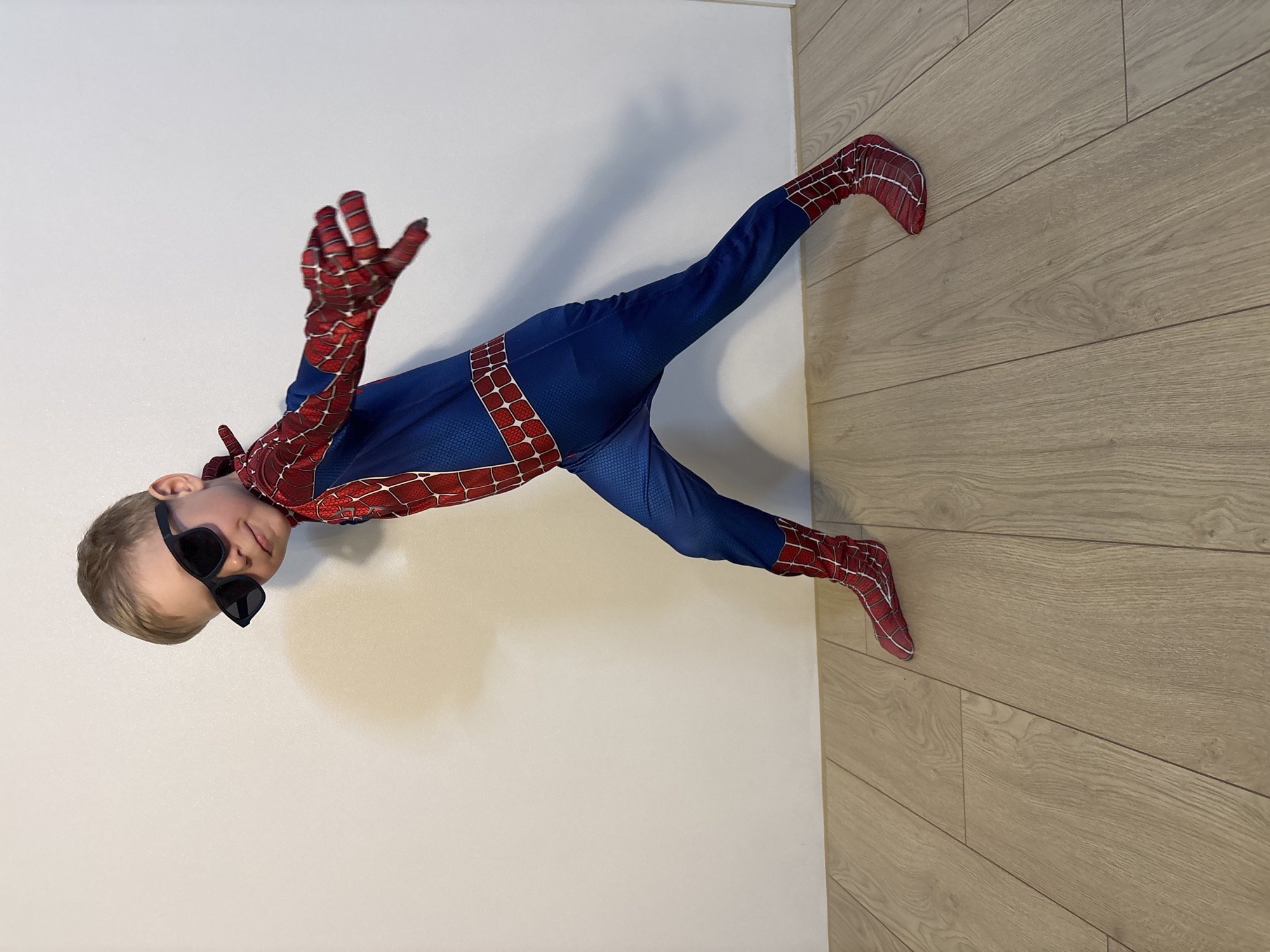 Mother and child in Spider-Man costume share playful moment indoors