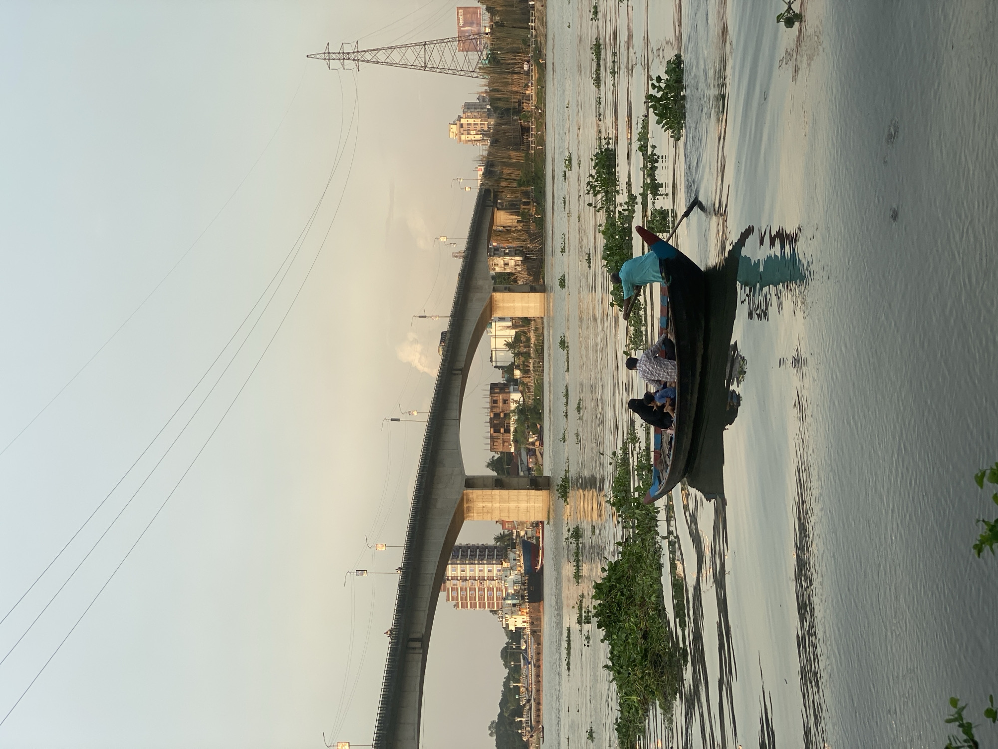Boats, bridges, and industry along the Buriganga River in Dhaka