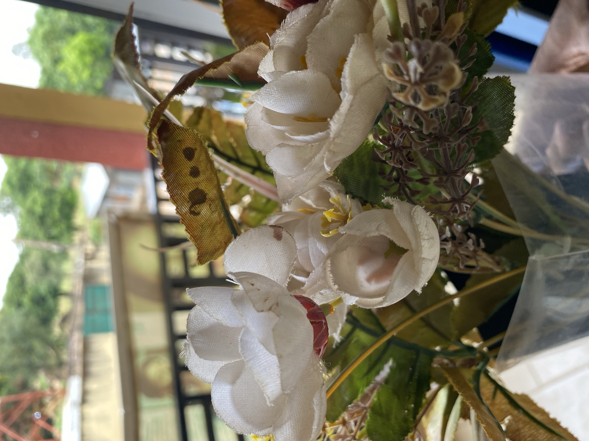 Artificial flower arrangement documented in Bukuru indoor setting