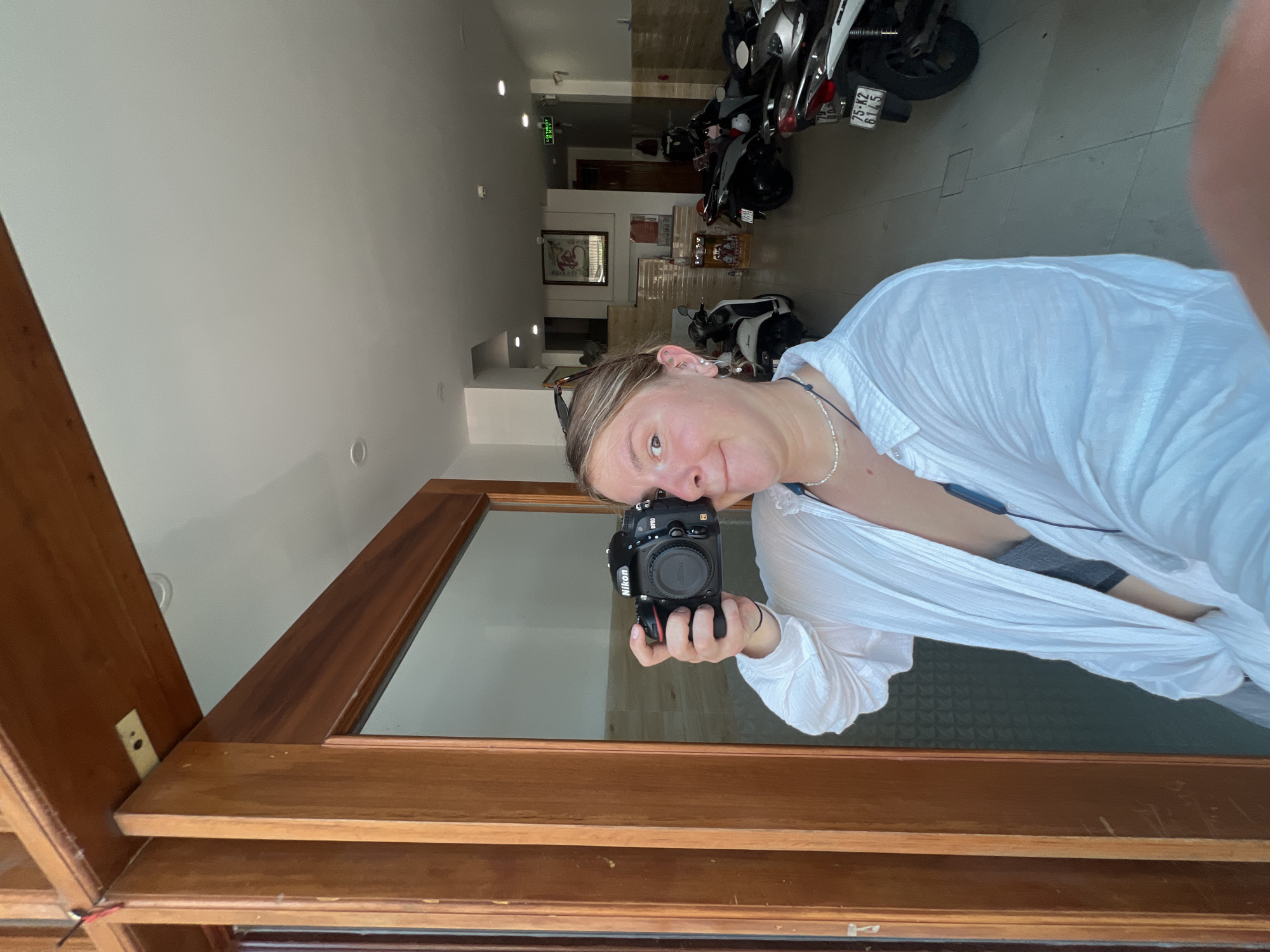 Woman takes mirror selfie with Nikon camera in Vietnam