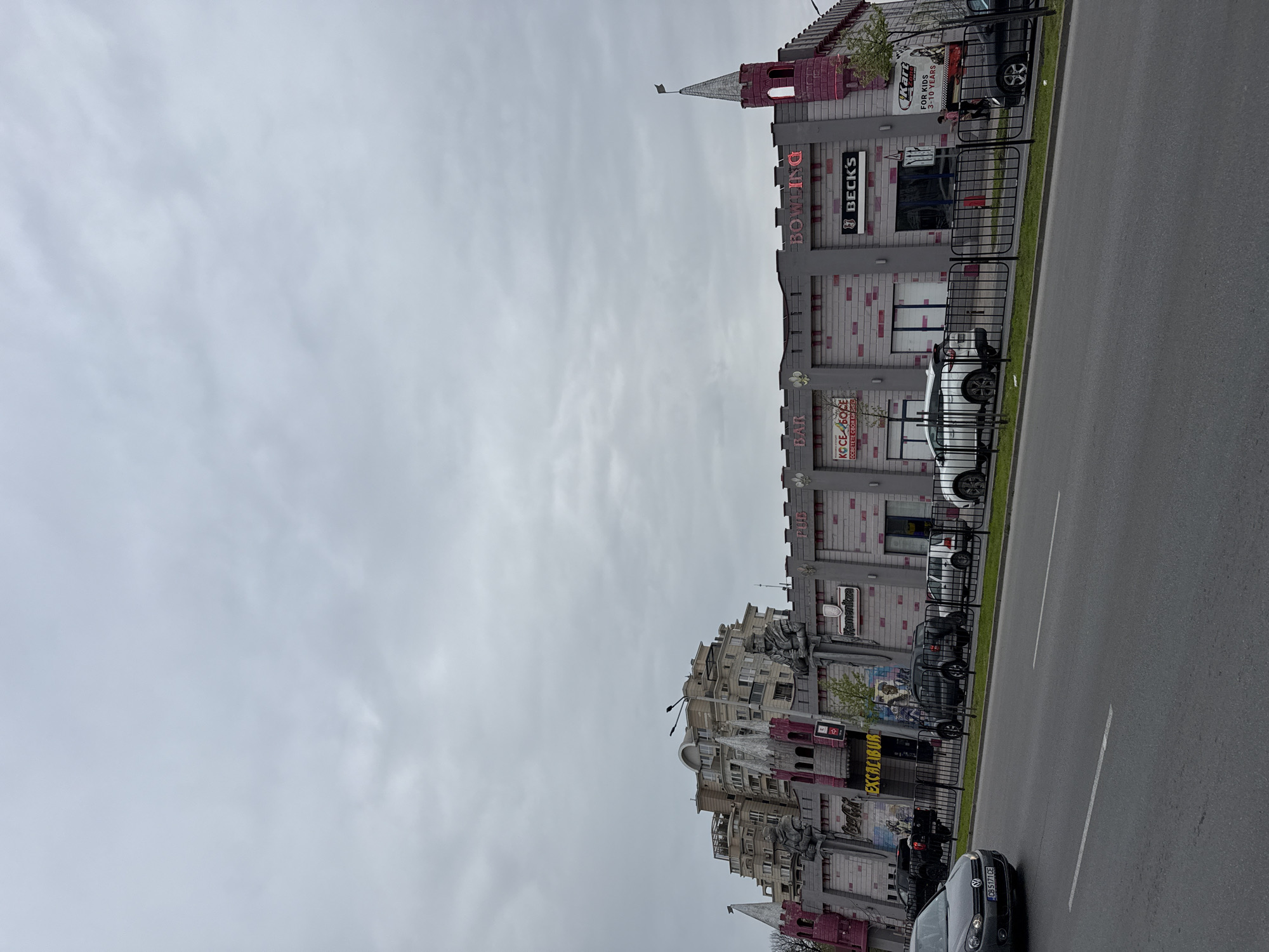 Person in pink hoodie walks past castle-themed building in Plovdiv