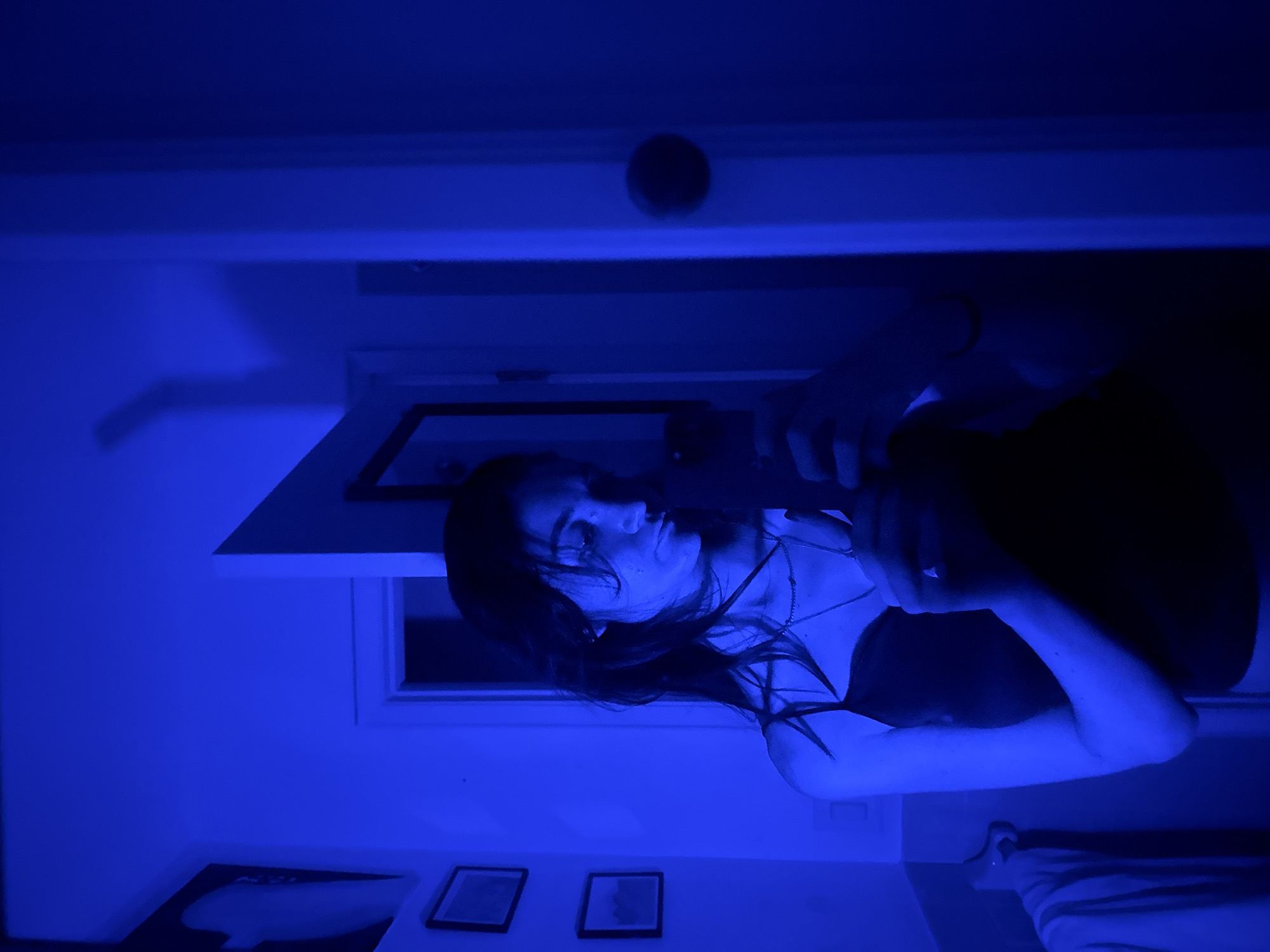 Woman observed under blue lighting in New York interior