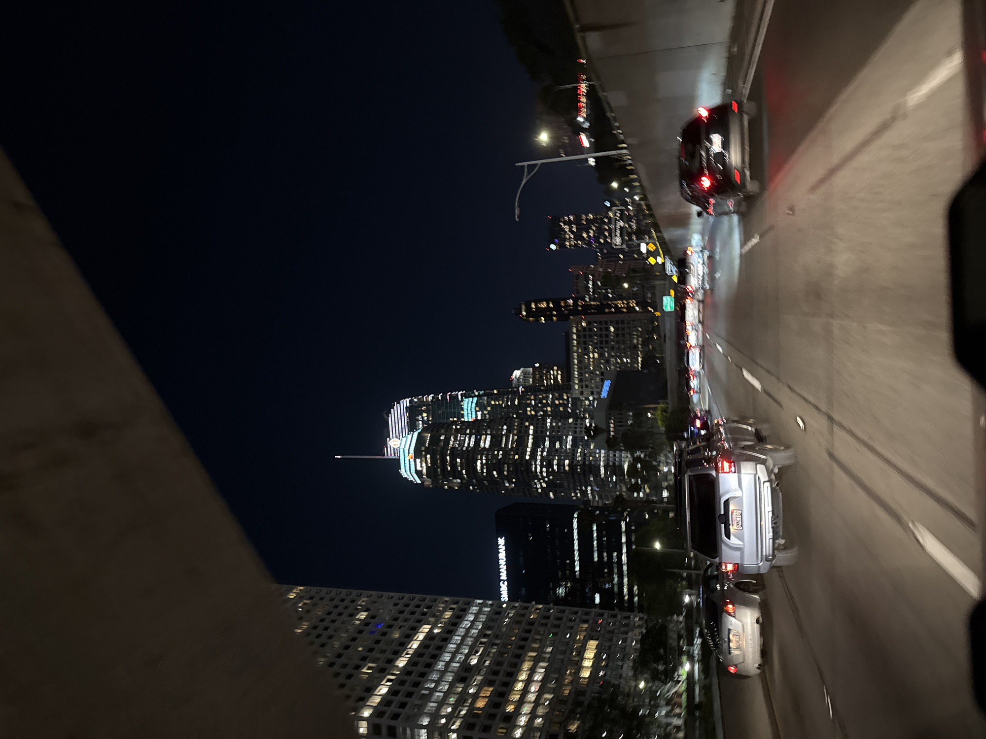 Early morning traffic flows beneath illuminated LA skyline