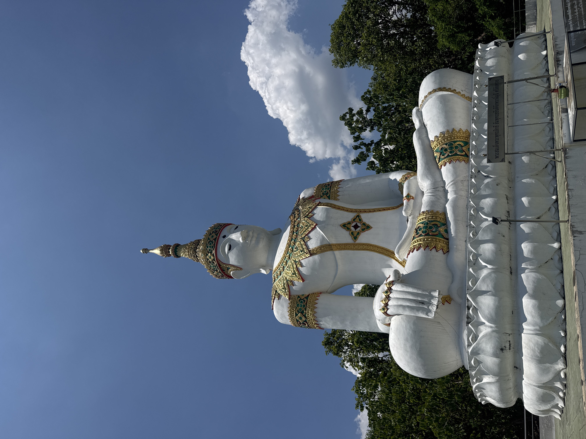 Visitors document ornate Buddha statues at Thailand temple complex