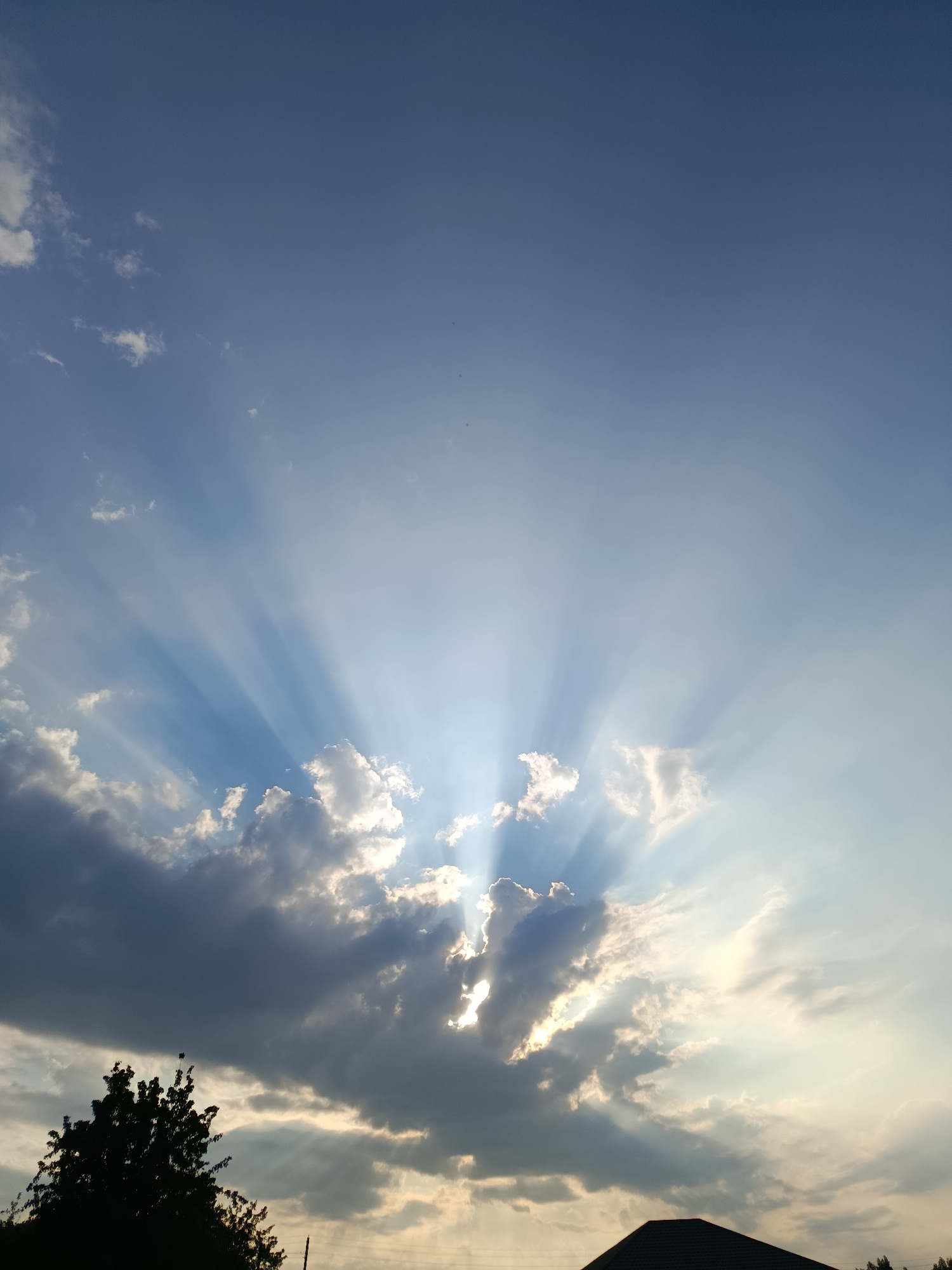 Sunbeams push through dark clouds at the edge of day