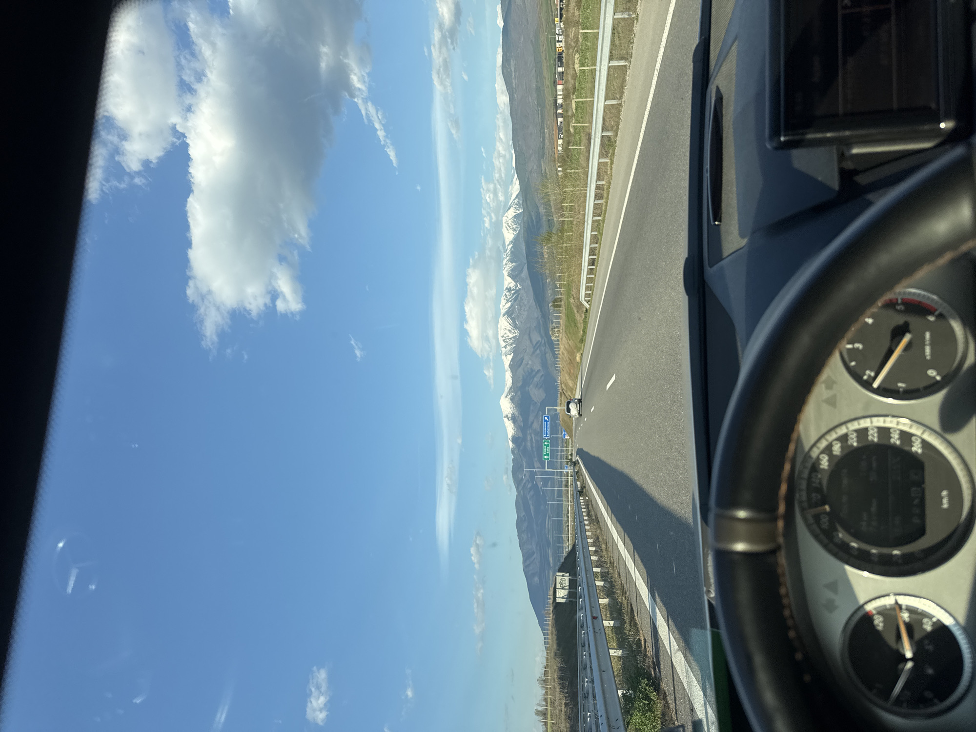 Driver navigates highway near Belo Pole amid mountain scenery