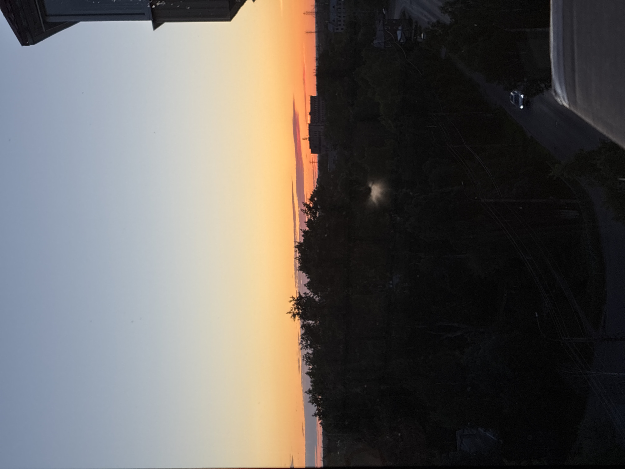 Sunset observed across city skyline during evening hours