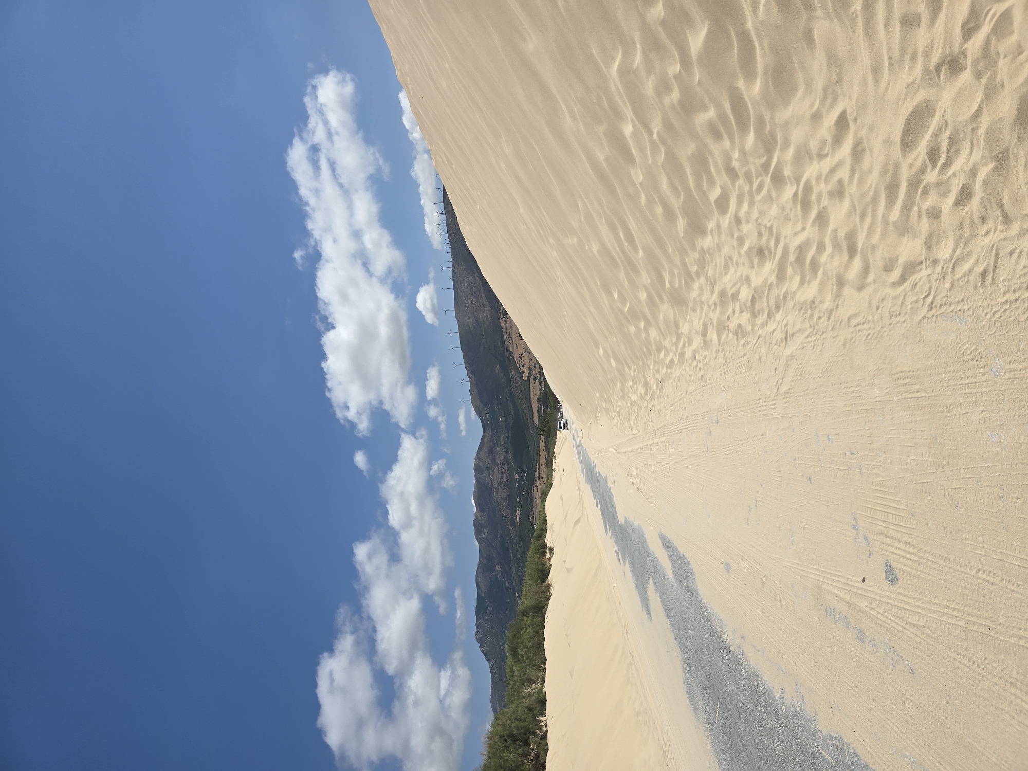 Sand-covered road winds through Tarifa's coastal dunes