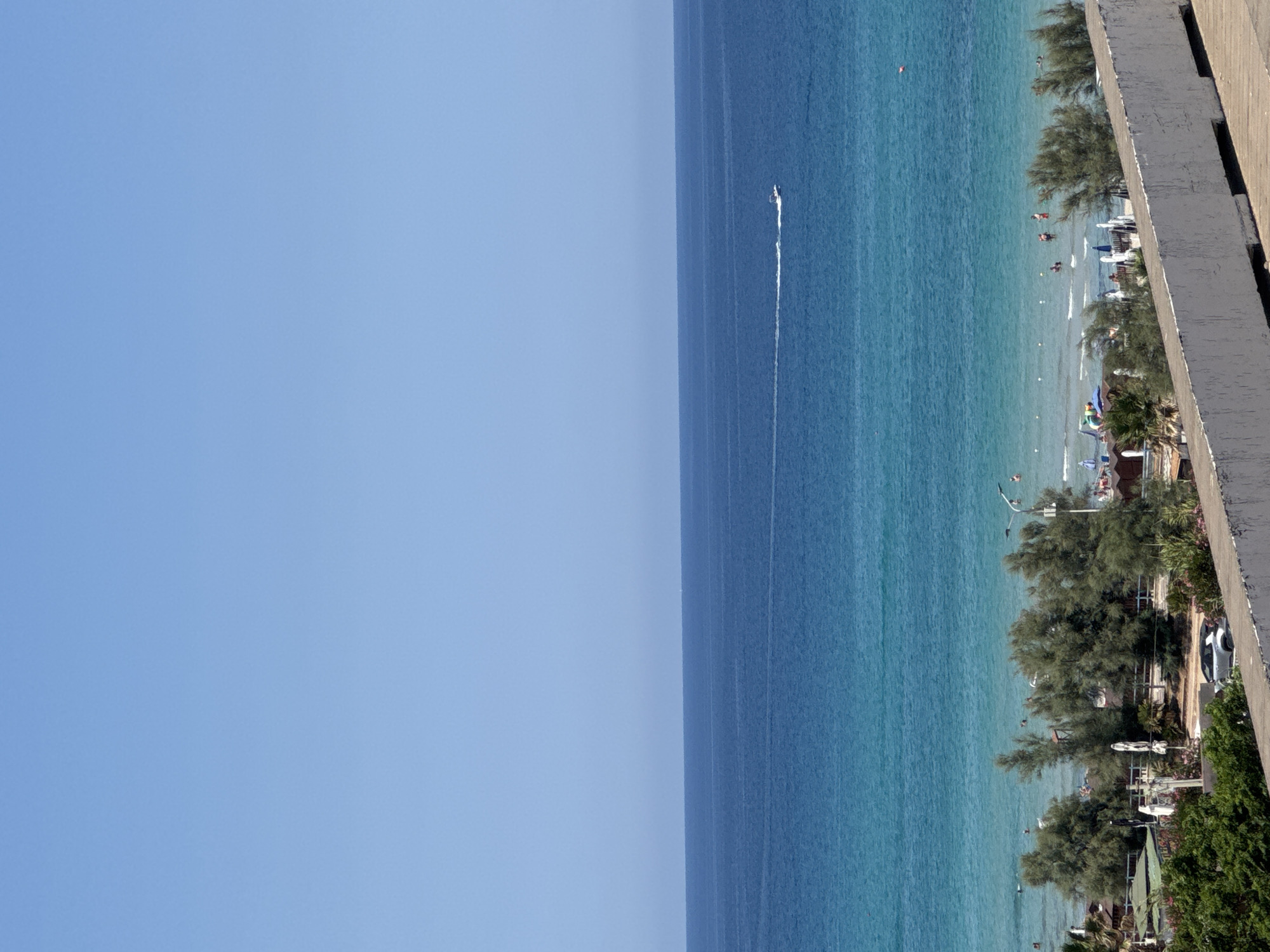 Sailboats, turquoise water, and rocky coast at Isola delle Femmine