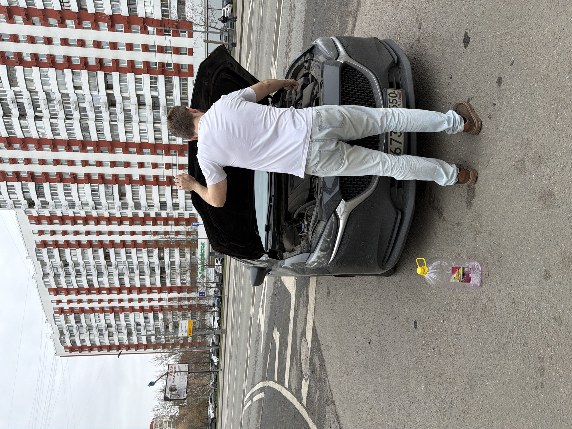 Man performs roadside car maintenance in Khimki