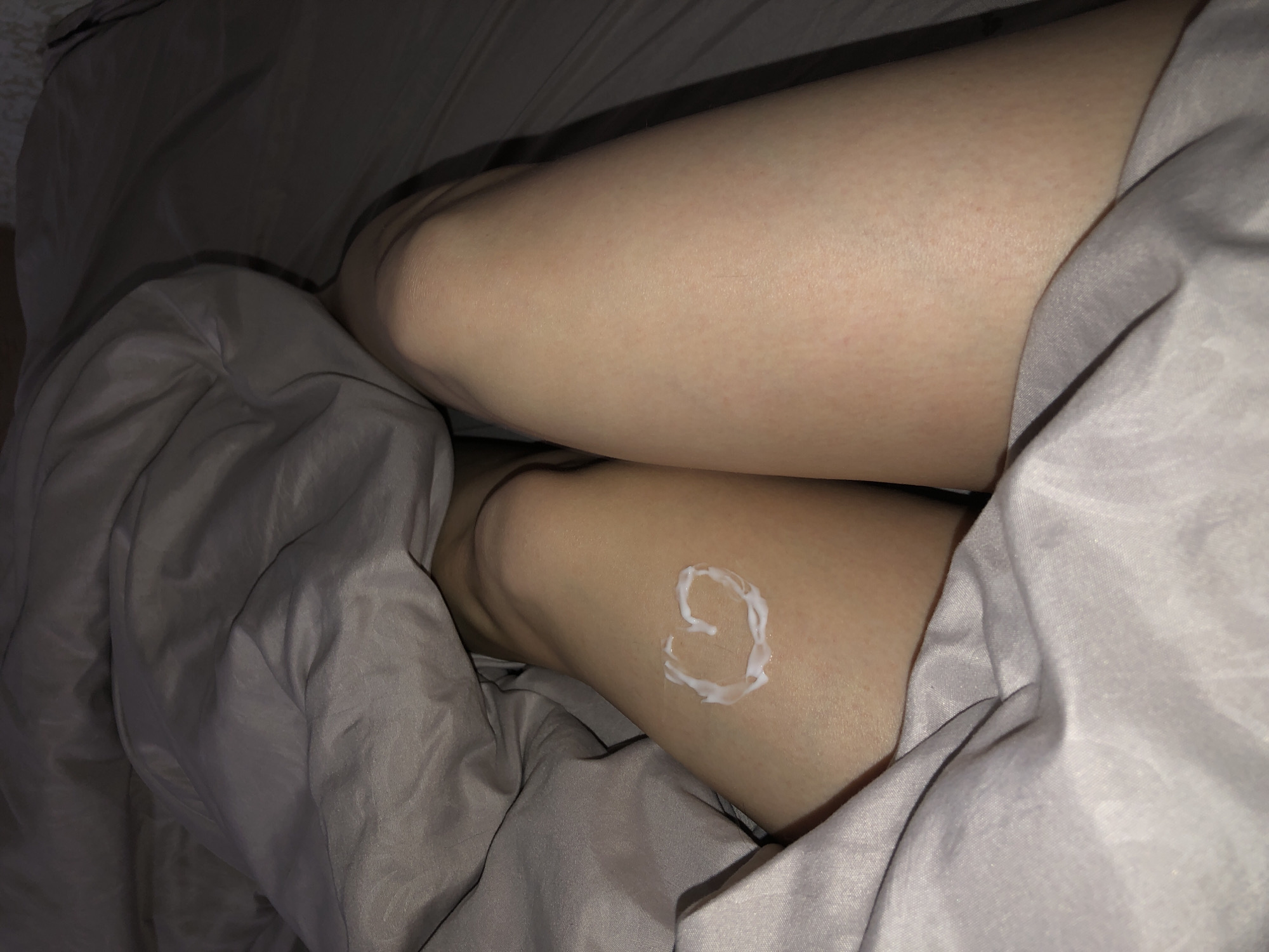 Person creates heart design with lotion on leg in Noviy