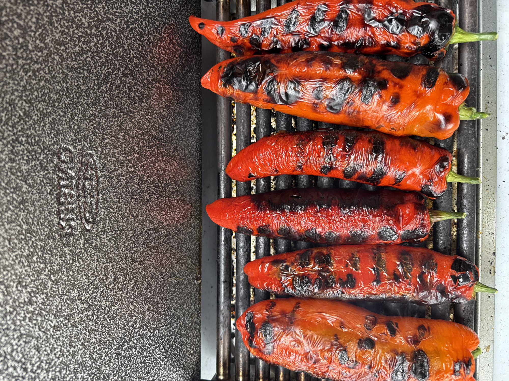Red bell peppers grilled on metal grate in London
