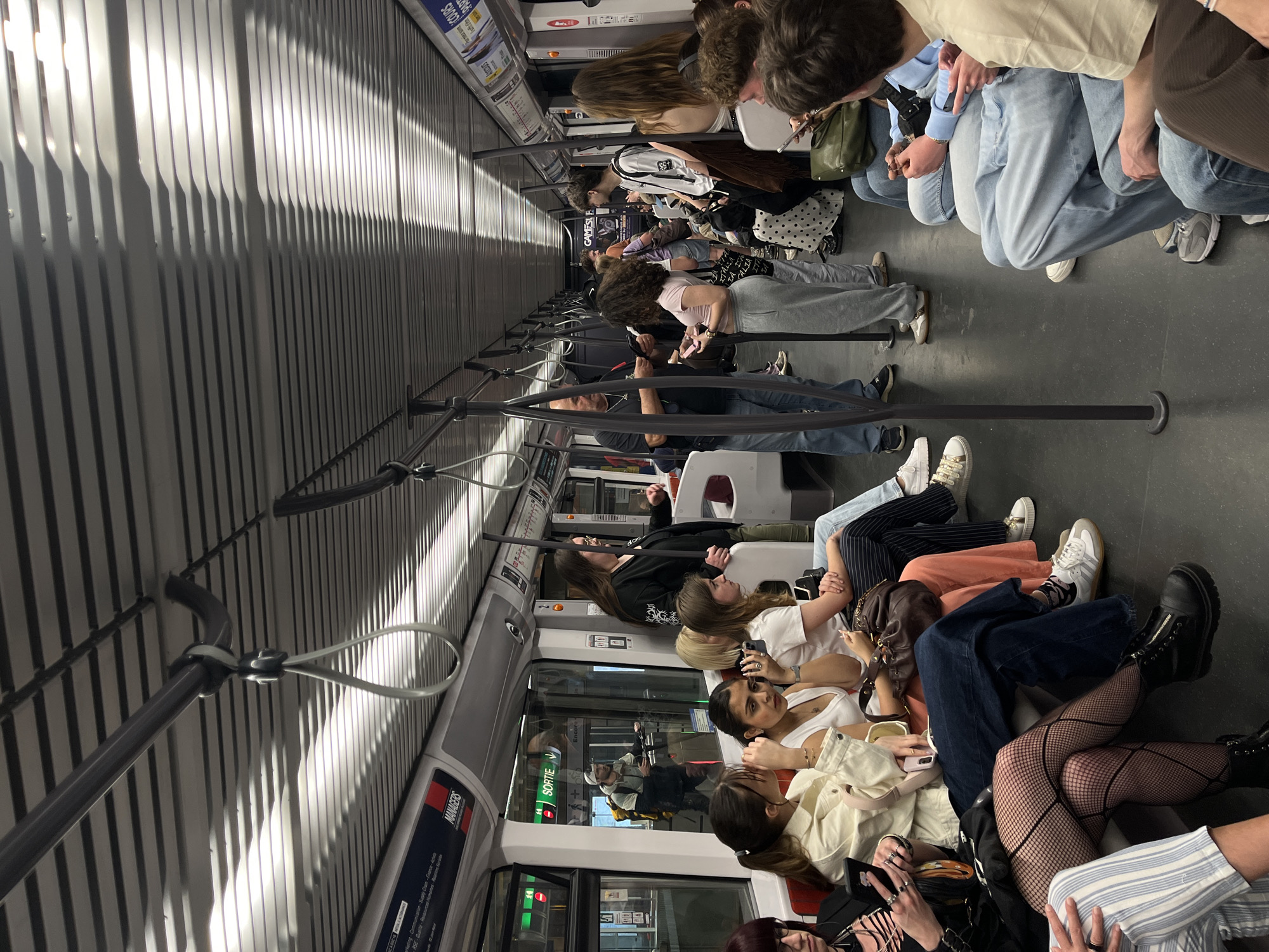 Evening commuters ride Lyon metro, passengers using phones