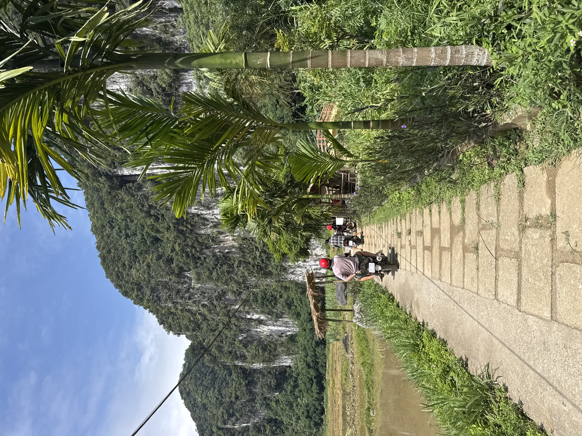 Tourists photograph scenic limestone landscape in Pù Luông Commune
