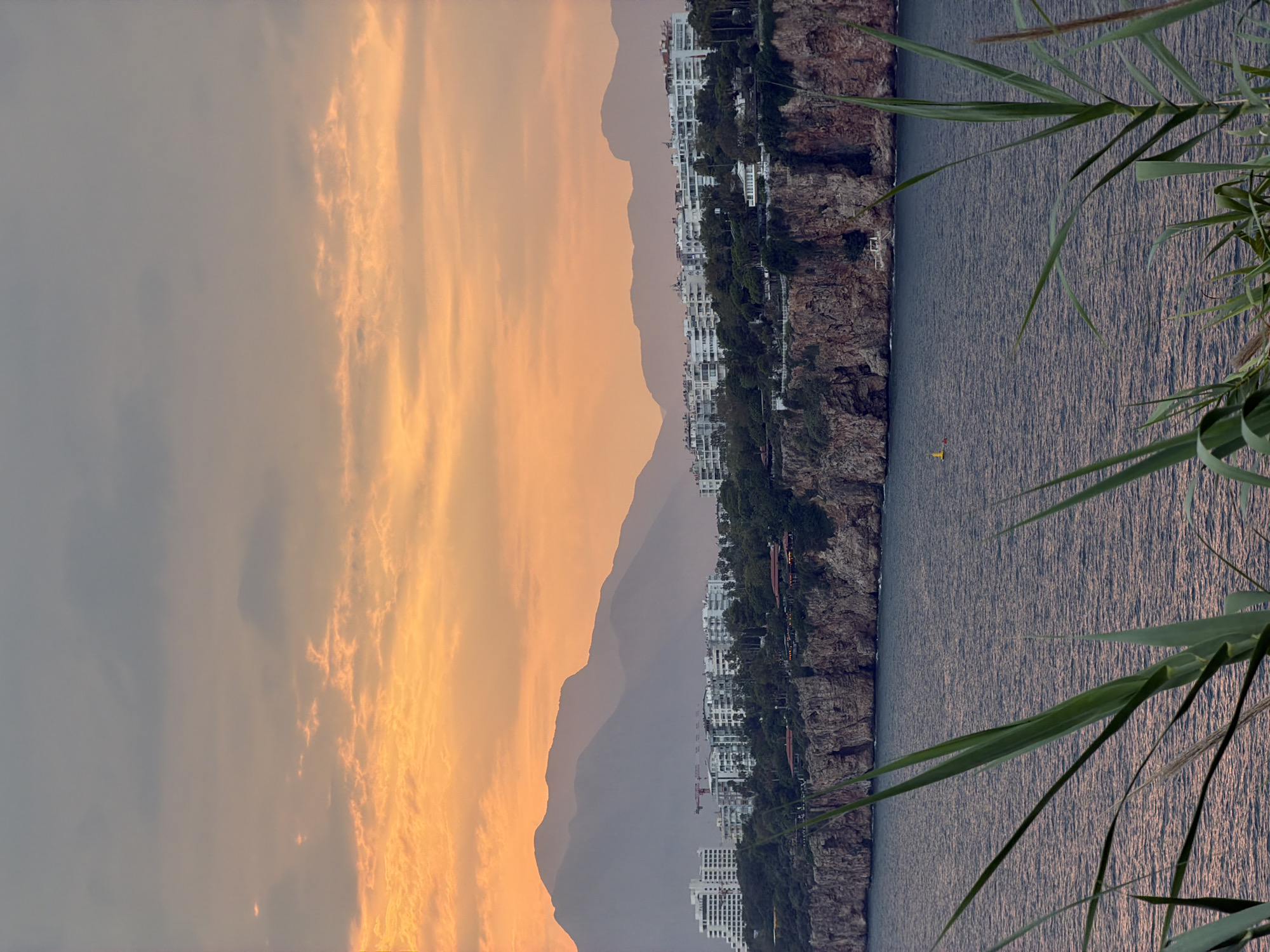 Sunset hour on Antalya's Mediterranean cliffs, boats and all