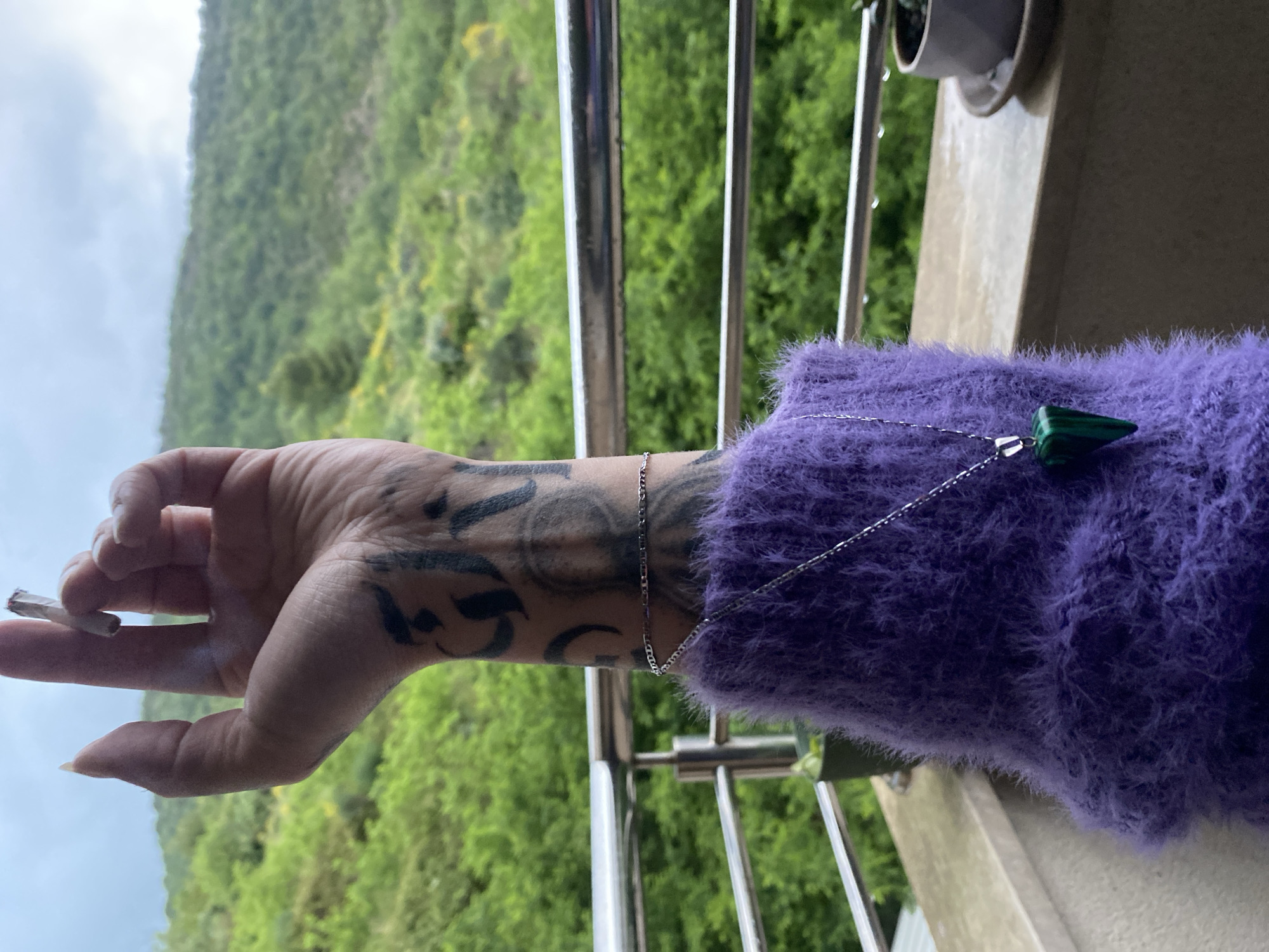 Person smokes on balcony overlooking Montenegro mountains