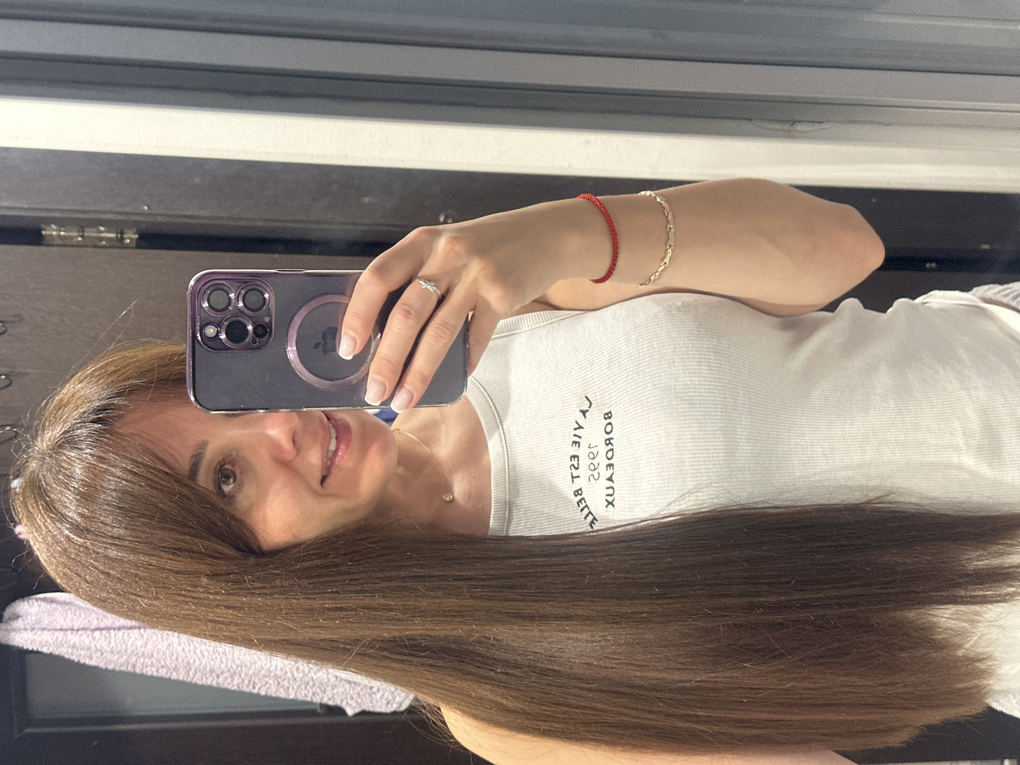 Woman Takes Mirror Selfie with Purple iPhone in Riga