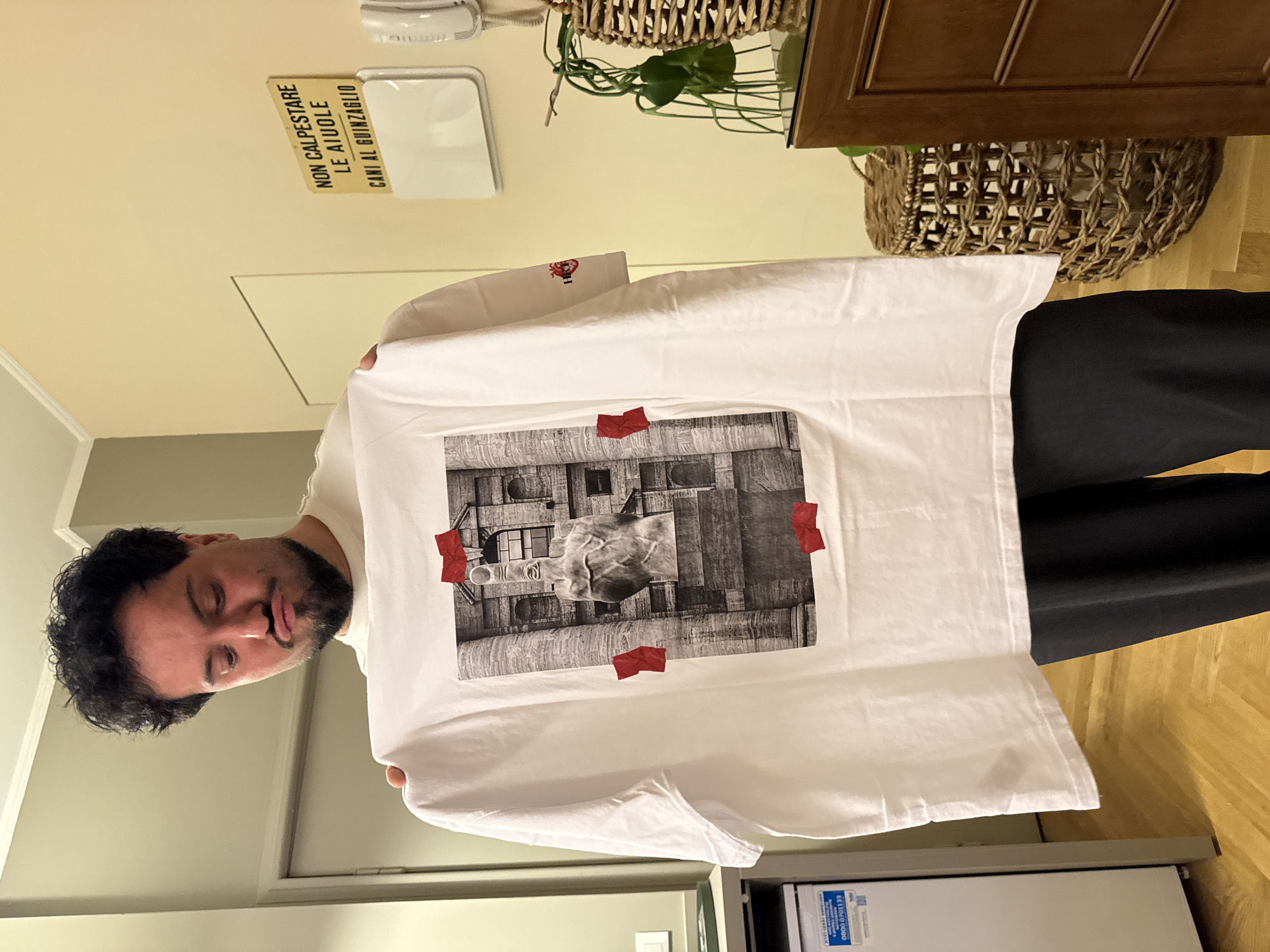 Man displays Cattelan L.O.V.E statue t-shirt in Milan