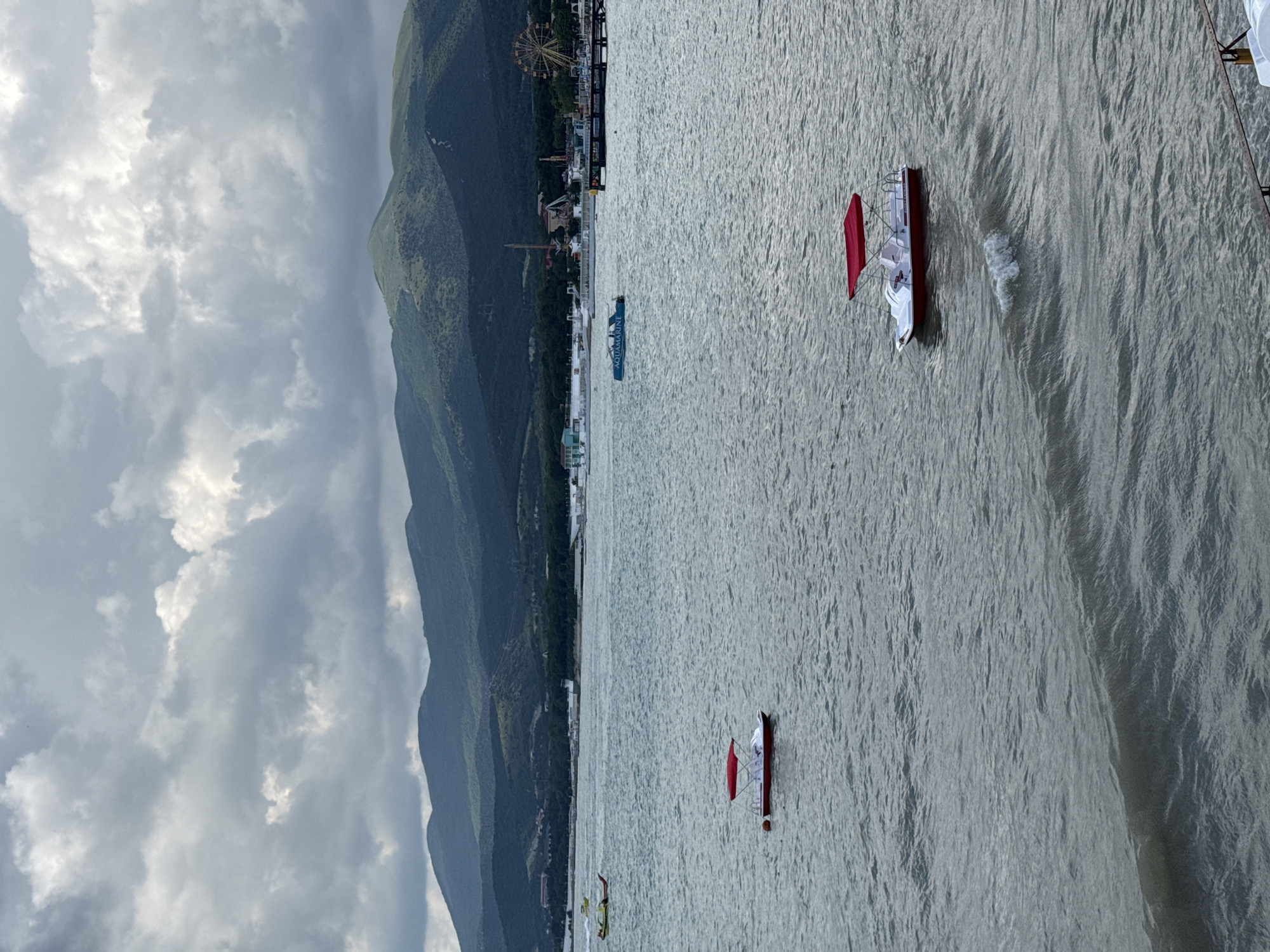 Cloudy beach day in Novorossiysk with pedal boats and crowds
