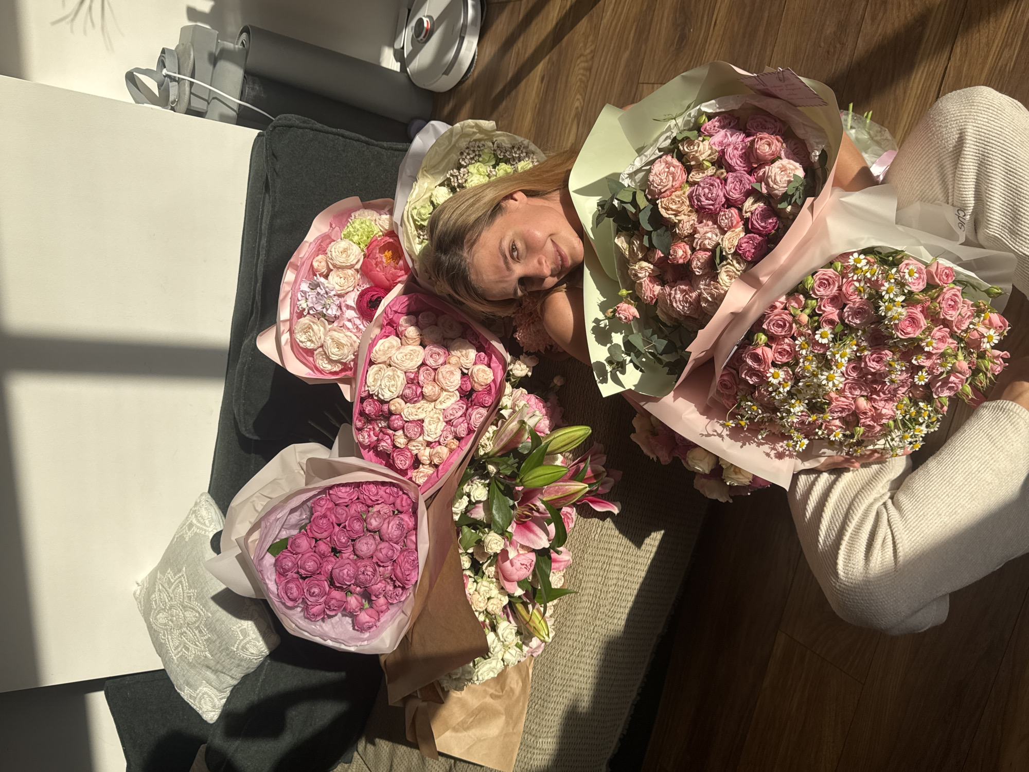 Woman surrounded by flower bouquets in indoor photoshoot session