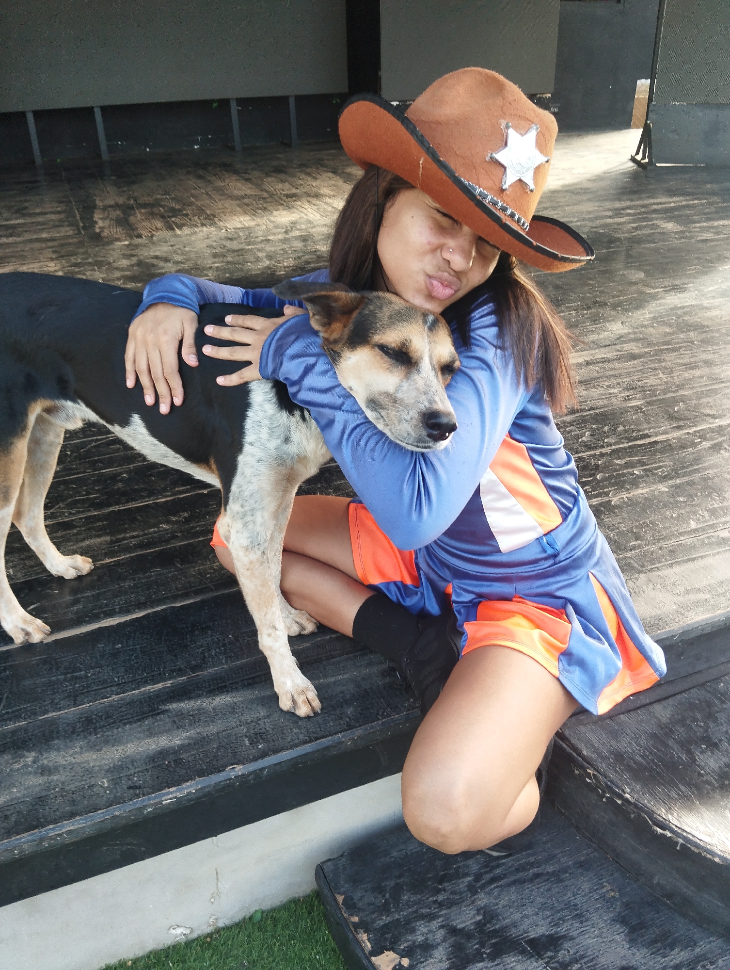 Person in cowboy hat shares quiet moment with dog