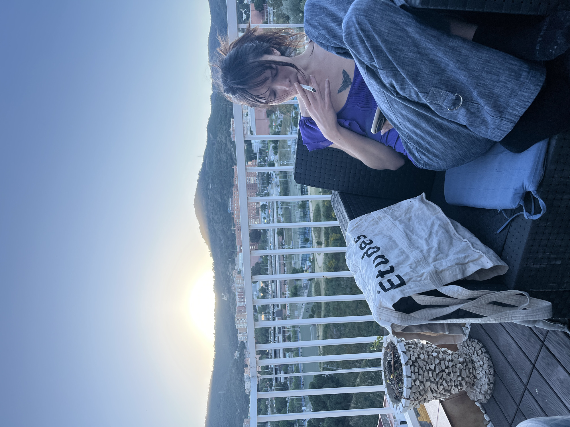 Woman and cat share quiet sunset moment on Barcelona balcony