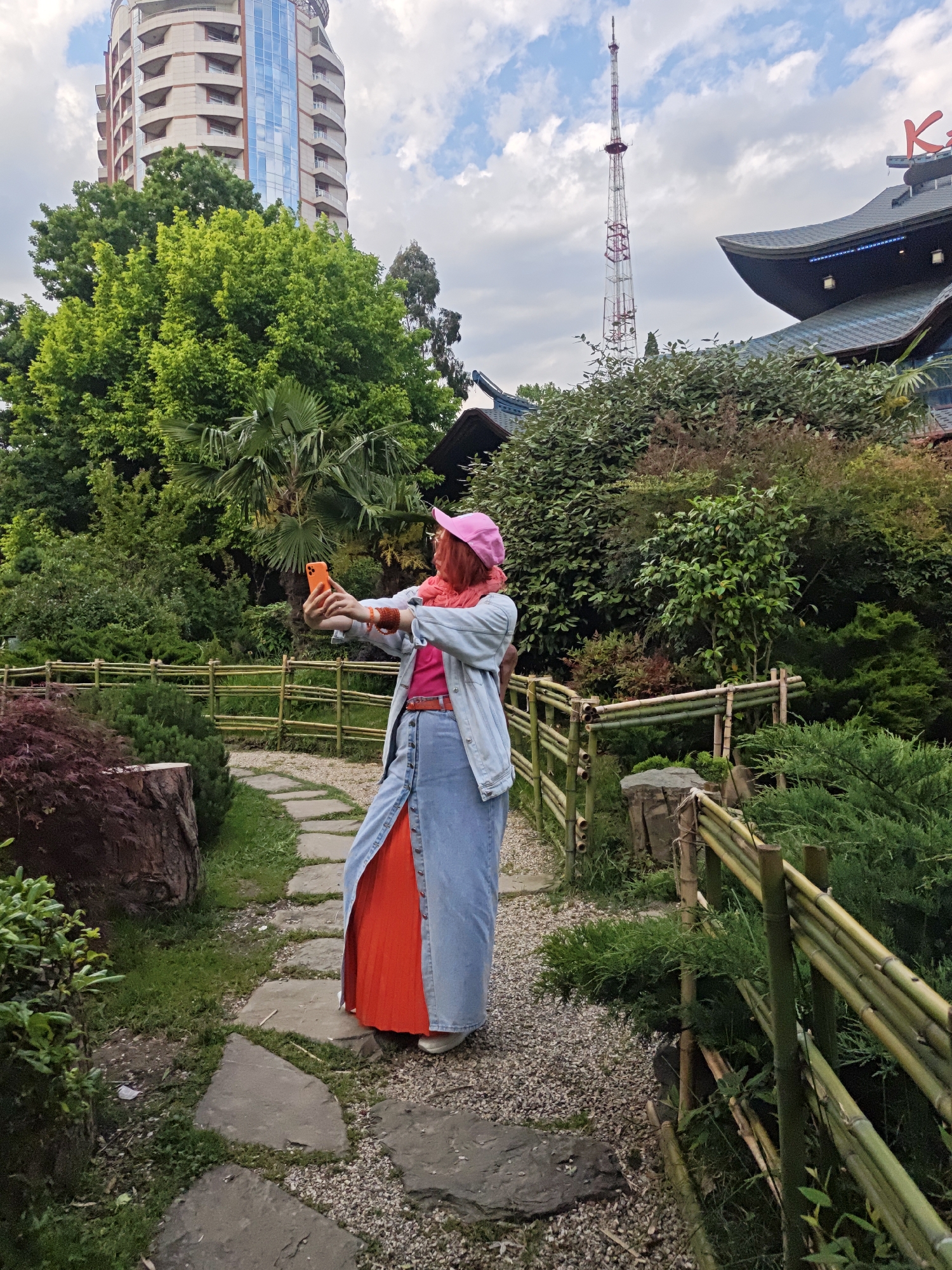 Woman Takes Selfies in Sochi Garden Near Restaurant