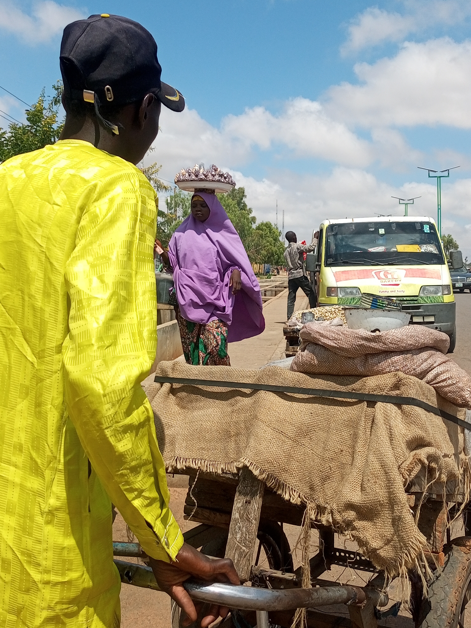 Street activity across two rural Nigerian villages, July morning