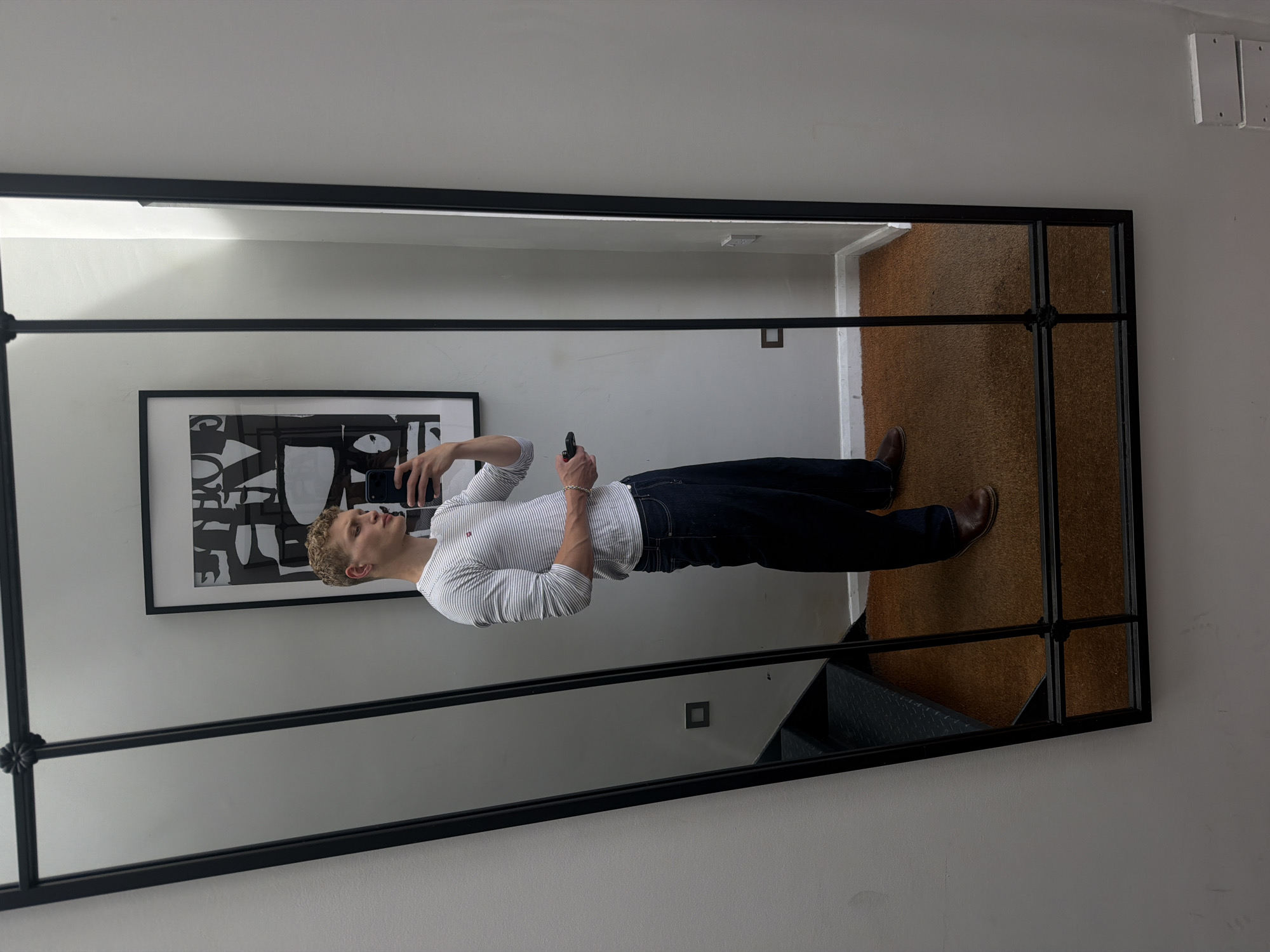 Mirror selfie in a London room, casual daytime fit