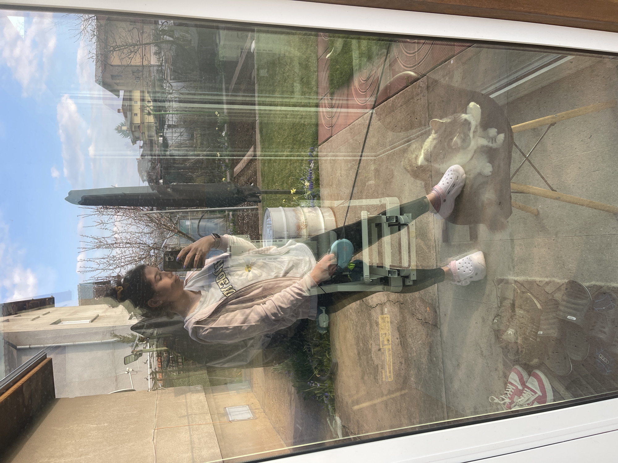 Woman photographing through reflective window in Sofia morning scene
