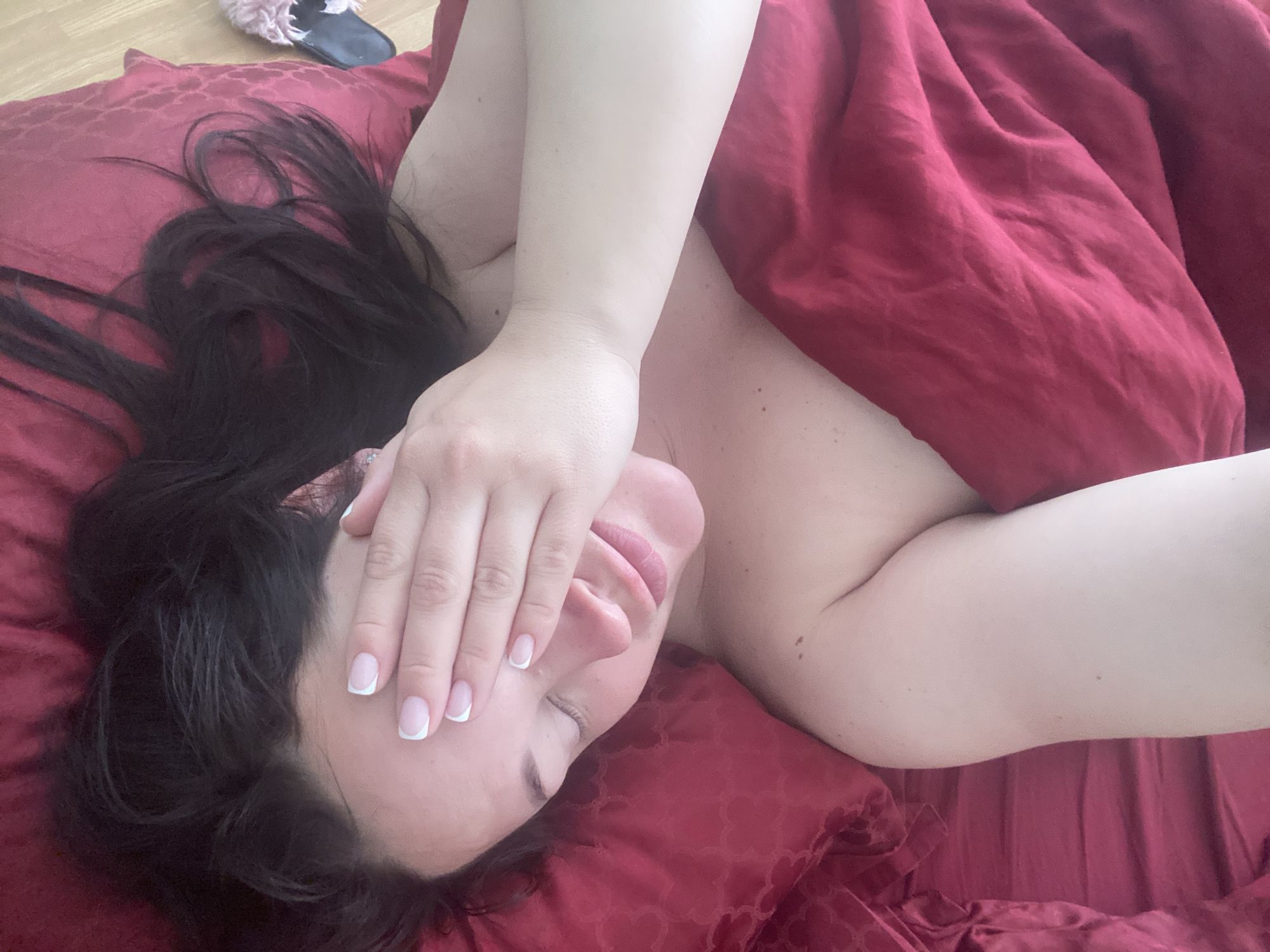 Woman rests on red bedding in Sochi early morning