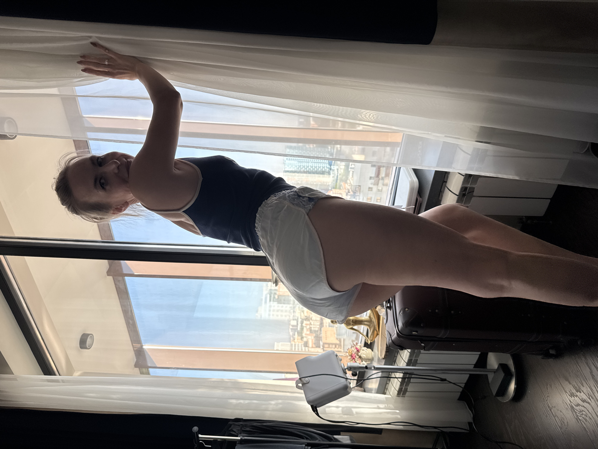 Woman observed in Novosibirsk apartment near window overlooking cityscape