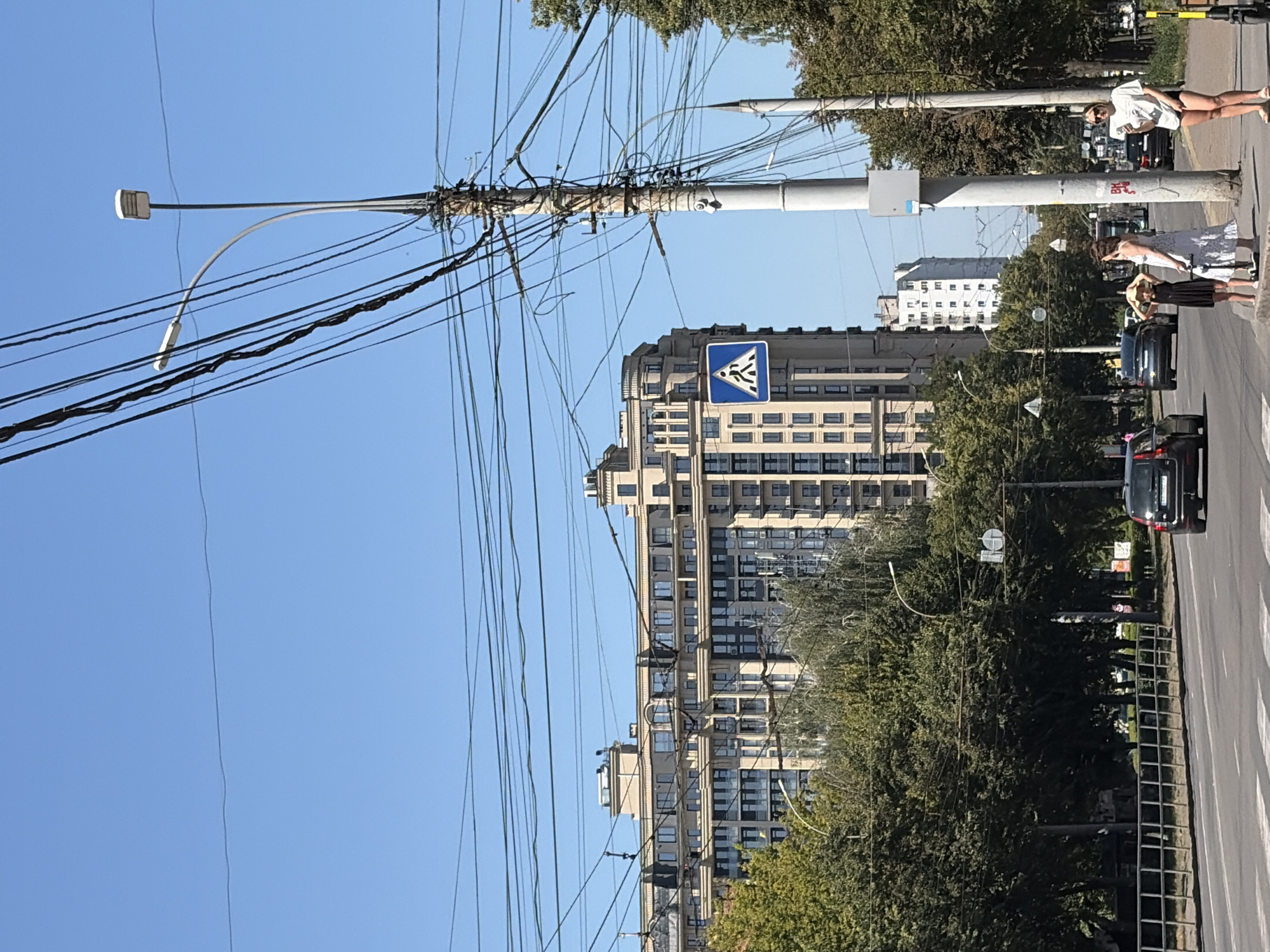 Tram 303 rolls through a sunny city intersection