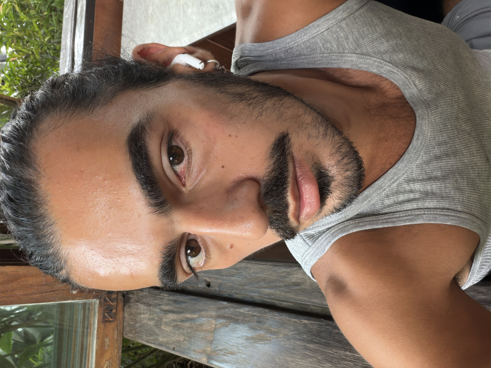 Man takes selfie on wooden bench in North Kuta