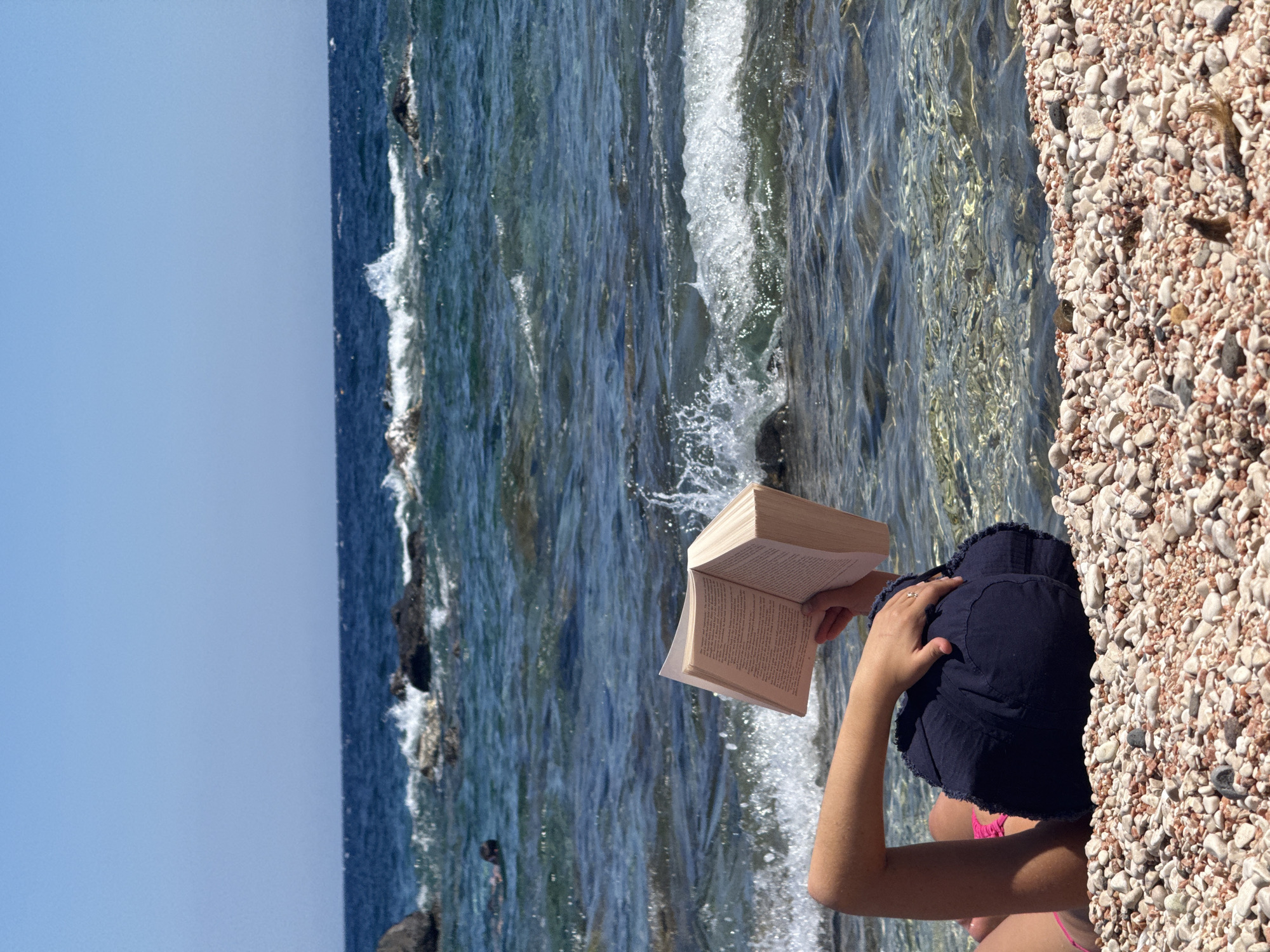 Afternoon reading session on a Sardinian pebble beach