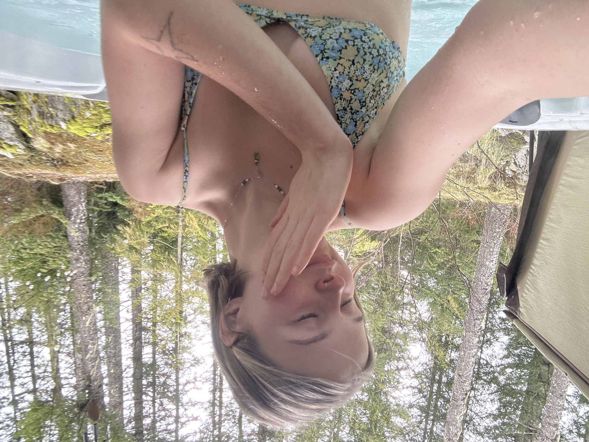 Woman relaxes in outdoor forest hot tub in Whistler