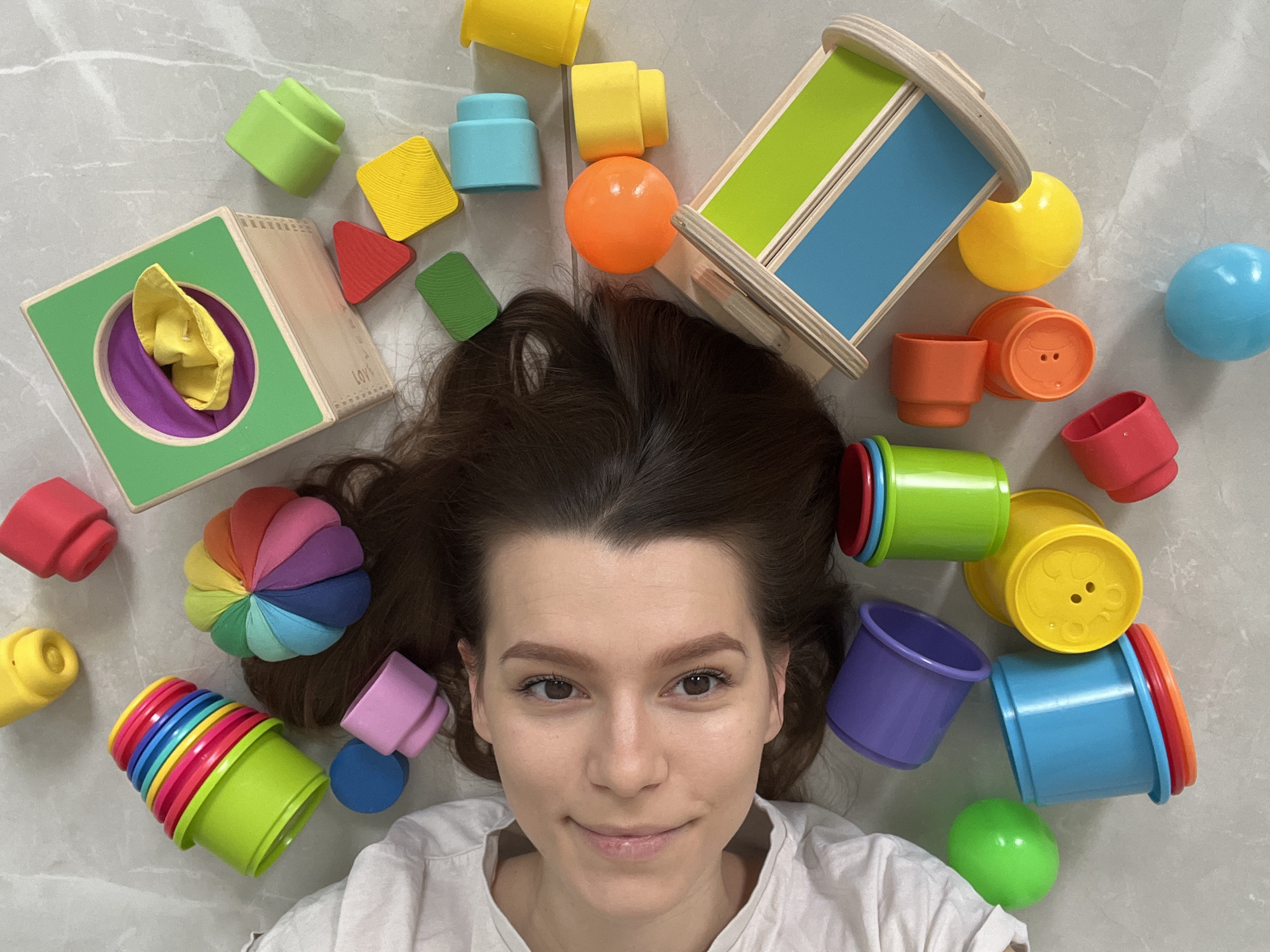 Woman plays with children's toys on floor in Cyprus