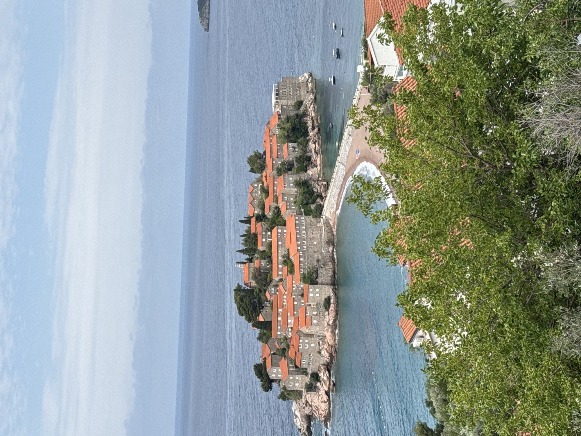 Tourists document scenic views of Montenegro's Sveti Stefan island village