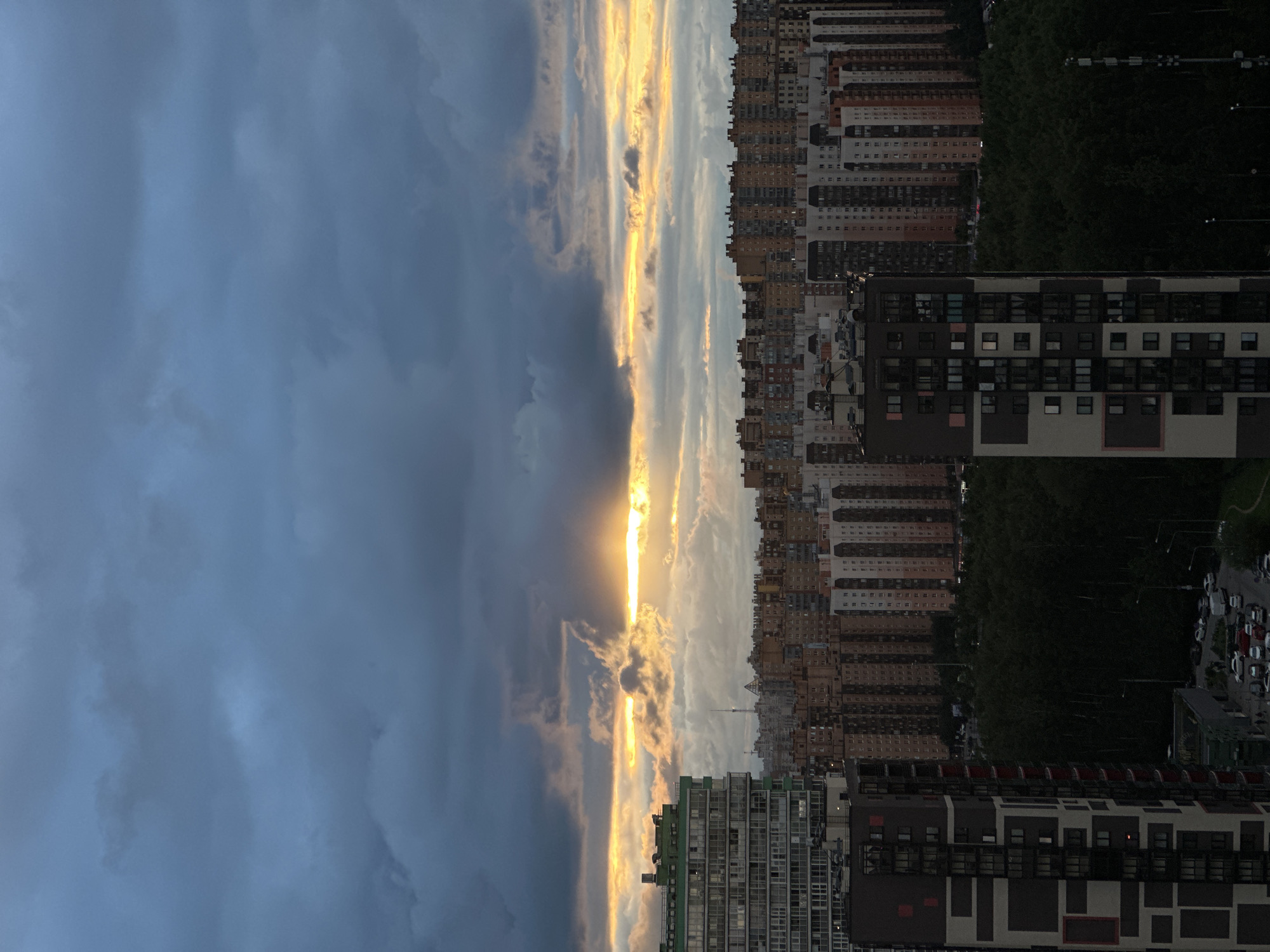 City skyline at dusk under a dramatic stormy sky