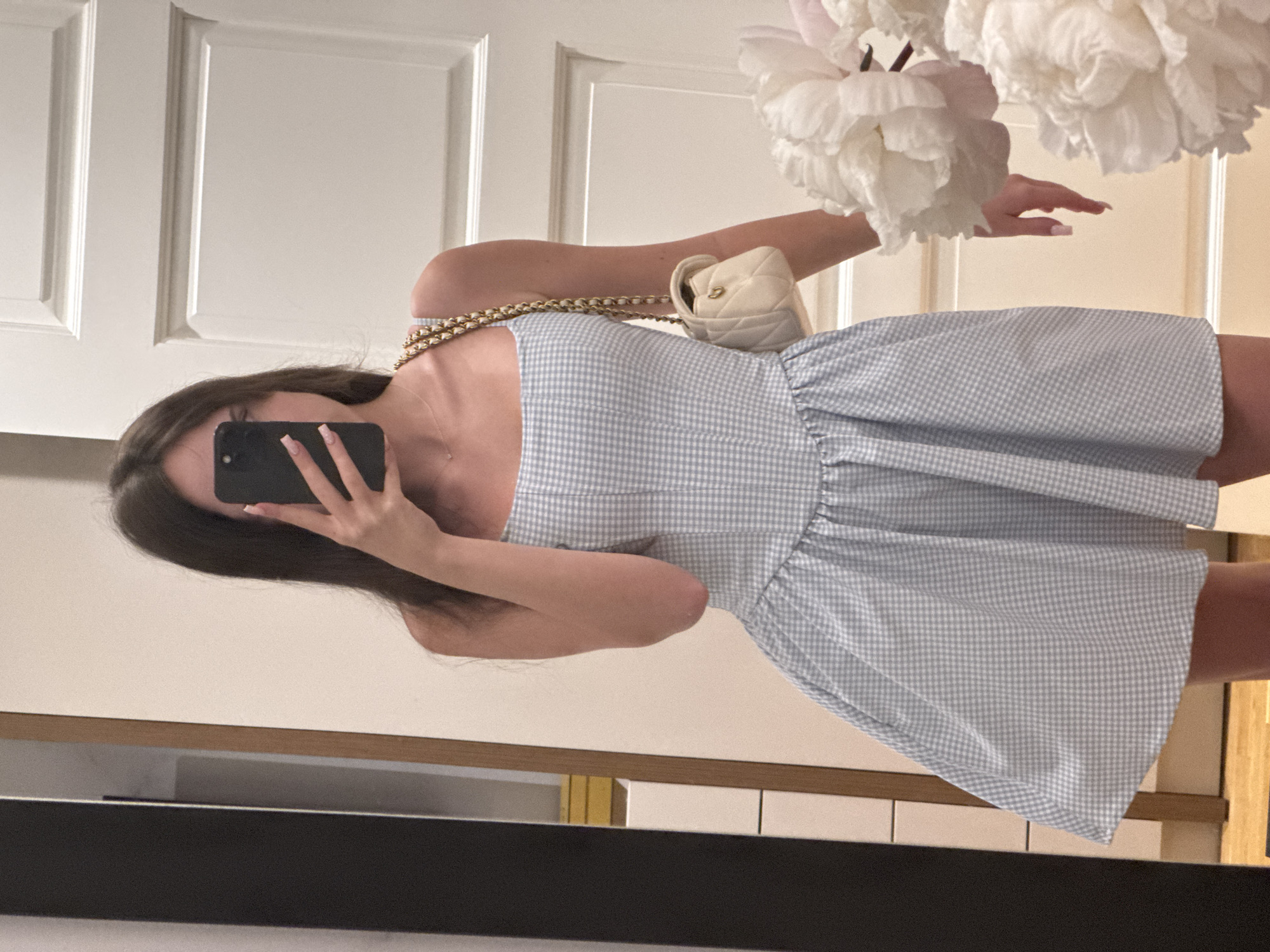 Woman takes mirror selfies in gingham dress
